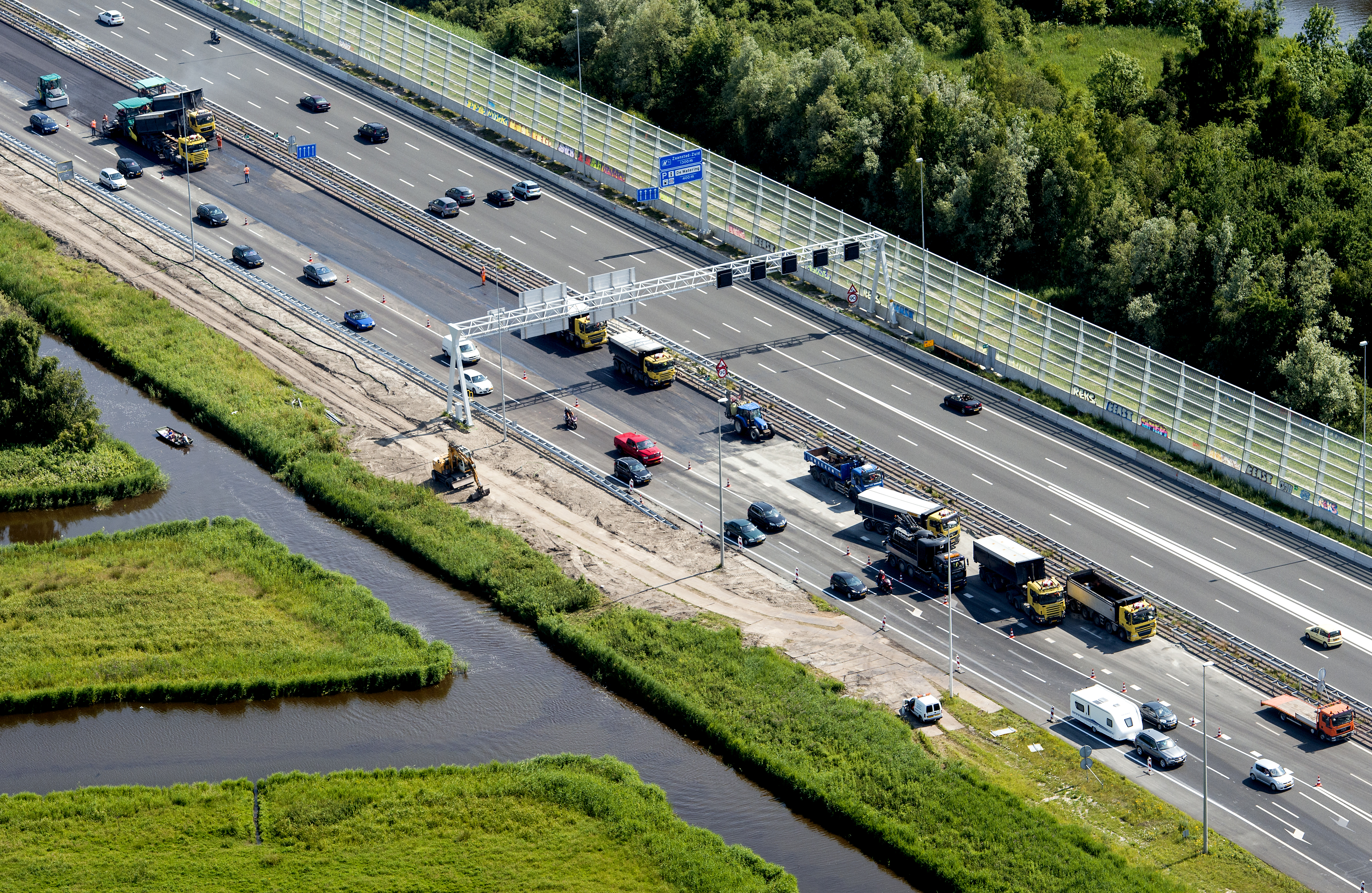 De snelwegen A7 en A8 ten noorden van Amsterdam moeten worden verbreed en aangepast om toekomstig fileleed te voorkomen. Als dat niet gebeurt, ontstaan er in 2030 flinke problemen op deze wegen. Ook de A9 moet onder handen worden genomen, maakte minister Melanie Schultz van Haegen (Infrastructuur) donderdag bekend in Westzaan. Ze gaf samen met de provincie Noord-Holland en de stadsregio Amsterdam het startsein voor de aanpak van de snelwegen, die volgend jaar begint met een onderzoek naar het verbreden en aanpassen van de A7 en A8 tussen de Coentunnel en Purmerend-Noord. Hiervoor is 300 miljoen euro gereserveerd in het Infrastructuurfonds. A8 doortrekken Daarnaast willen de provincie en stadsregio de A8, die nu ophoudt ter hoogte van Westzaan, doortrekken via een nieuwe provinciale weg naar de A9 bij Heemskerk. Hierdoor verdwijnt het doorgaande verkeer uit de woongebieden van Krommenie en Wormerveer. Dit project komt voor rekening van de provincie en regio. Zij hebben hiervoor 110 miljoen euro uitgetrokken, maar de kosten worden hoger ingeschat op zo'n 150 miljoen euro. Naar het restant zoeken de partijen nog, zei gedeputeerde van de provincie Elisabeth Post. Volgens haar wordt al 39 jaar over dit project gesproken. Nieuwe technieken De minister wil verder op de A9 tussen Alkmaar en Raasdorp de filedruk verminderen door inzet van nieuwe technieken om het verkeer beter te begeleiden. Ze gaat met het bedrijfsleven in overleg om meer werknemers uit de spits te halen. Ook wordt gekeken naar gebruik van de reservecapaciteit van de beide Coentunnels, die na opening in 2014 nog ruimte hebben voor twee extra rijstroken. Hierdoor is uitbreiding naar zes en vier rijstroken mogelijk. Milieudefensie kritisch Milieudefensie is kritisch op de plannen van Schultz. "De minister wil weer asfalteren en dat is in dit geval echt de domste oplossing." Een woordvoerder van Milieudefensie laat weten dat de minister voorbijgaat aan maatschappelijke ontwikkelingen. "Er komt helemaal geen flinke groei van het aantal auto's, zoals zij denkt. Door vergrijzing en de crisis, jongeren die in de stad wonen en geen auto kopen, meer flex- en thuiswerkers en dus steeds minder forensen. Dus het is heel raar om nu zo veel asfalt neer te leggen dat er straks werkloos bij ligt. Want het geld is ook hartstikke op.'' Wel enthousiast reageerden de provincie Noord-Holland en de Stadsregio Amsterdam. Gedeputeerde Elisabeth Post (VVD) zei heel blij te zijn met de investeringen in de bereikbaarheid van het gebied. VVD-wethouder Dennis Straat van Zaanstad meldde namens de stadsregio dat samenwerking het devies is. "Het Rijk richt zich op de A7, A8 en A9 en wij als regio richten ons op doortrekken van de A8." De stadsregio steekt hier volgens hem 40 miljoen euro in.