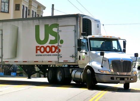 De Amerikaanse voedseldistributeur Sysco neemt zijn branchegenoot US Foods over. Dat werd maandag bekendgemaakt. US Foods was onder de naam US Foodservice tot 2007 eigendom van Ahold en was een van de hoofdrolspelers in het boekhoudschandaal rond het supermarktconcern. De overnamesom ligt op circa 3,5 miljard dollar (2,6 miljard euro), waarvan 3 miljard dollar in aandelen Sysco wordt voldaan. Daarnaast zal Sysco de schuld van US Foods herfinancieren. Daarmee komt de totale ondernemingswaarde van laatstgenoemde partij op 8,2 miljard dollar. Ahold ontving in 2007 een bedrag van 7,1 miljard dollar voor het bedrijf. Jaaromzet: 65 miljard dollar Wanneer de deal is afgerond, naar verwachting in het derde kwartaal van 2014, zal het gecombineerde concern een jaarlijkse omzet hebben van 65 miljard dollar. Zo'n drie jaar na de overname worden jaarlijkse kostenvoordelen voorzien van ongeveer 600 miljoen dollar. De huidige topman van Sysco, Bill DeLaney, zal het gecombineerde concern gaan leiden. De huidige aandeelhouders van US Foods zullen na afloop van de transactie ongeveer 13 procent van de aandelen Sysco in handen hebben. De grootaandeelhouders Clayton, Dubilier & Rice en Kohlberg Kravis Roberts (KKR) leveren ook een bestuurder.