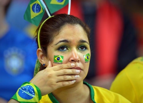 Brazilië treurt na de afstraffing tegen Duitsland op het WK voetbal. Als de eerste teleurstelling is weggeëbd, kon de nederlaag weleens positief zijn voor de economie van het Zuid-Amerikaanse land. De Braziliaanse pers reageert met treurnis en erkenning voor de Duitse prestaties op de halve finale van het WK. Brazilië verloor dinsdag met maar liefst 7-1 van de Duitsers, die na de eerste helft al op een 5-0 voorsprong stonden. Een "historische vernedering'', schrijft de Estado de São Paulo. "In het land van het voetbal heeft Duitsland een les geleerd'', met "indrukwekkende organisatie en tactische discipline''. De Folha de São Paulo rept over een "historisch debacle'' en "herkent'' de Seleção niet meer die door die Mannschaft is "afgemaakt'' en "afgeschoten''. Sportkrant Lance! rept over "de grootste schande van de geschiedenis'' en een "weergaloze marteling''. Nationaal trauma De klap komt ongetwijfeld hard aan in het voetbalgekke land, dat het WK voor de tweede keer organiseert maar wederom een nationaal trauma oploopt. In 1950 verloor Brazilië de WK-finale in eigen land door een blunder van keeper Barbosa. Nu is het afgeslacht door de Duitsers. Maar hoe hard de nederlaag ook aankomt, de uitschakeling kan op lange termijn positief uitpakken voor de Braziliaanse economie. De kans dat president Dilma Rousseff, die de economie maar niet aan de praat krijgt, in oktober van dit jaar wordt herkozen is fors geslonken. En daar zullen beleggers blij mee zijn, aldus analisten van UBS voorafgaand aan het toernooi. Braziliaanse economie stagneert Sinds haar aantreden in 2011, heeft Rousseff de nodige kritiek te verduren gekregen. Na veelbelovende groeicijfers aan het begin van het decennium, is de Braziliaanse economie weggezakt. Daarmee lijkt de status van Brazilië als 'opkomende economie' in het geding. De Braziliaanse economie groeit nauwelijks, in het eerste kwartaal van dit jaar slechts met 0,2 procent ten opzichte van de drie maanden daarvoor. De maatregelen die de regering onder leiding van Rousseff heeft doorgevoerd om de groei aan te jagen, hebben in plaats daarvan geleid tot meer inflatie en verslechterde overheidsfinanciën. Daardoor zijn het vertrouwen bij ondernemers en de bereidheid om te investeren afgenomen. Gewelddadige protesten De inflatie is opgelopen tot 6,52 procent in juni, boven het plafond van 6,5 procent dat de regering heeft vastgesteld. Allerlei goederen en diensten in Brazilië zijn vele malen duurder dan in de rest van de wereld, en dat heeft geleid tot grote onvrede onder de bevolking. Niet in de laatste plaats omdat Brazilië ondertussen miljarden euro's heeft geïnvesteerd in het organiseren van het WK voetbal, geld dat volgens veel Brazilianen beter besteed had kunnen worden. Voorafgaand aan het toernooi waren er gewelddadige protesten in veel steden. Betogers staken banden in brand en bouwden barricades. Verkiezingen in oktober De uitschakeling op het WK voetbal kan de genadeslag betekenen voor Rousseff, die de hoge kosten voor het WK voetbal verdedigde en een onvergetelijk wereldkampioenschap voorspelde. Dat is het zeker geworden, maar niet op de manier die Brazilianen hadden gehoopt. Nu de kans is toegenomen dat Rousseff de verkiezingen verliest en een marktvriendelijkere kandidaat het roer zal overnemen, zien investeerders wellicht mogelijkheden op de Braziliaanse markt. Sommige analisten voorspellen een rally op de Braziliaanse beurs van wel 25 procent. Maar er ligt een gevaar op de loer. De nederlaag tegen Duitsland is dermate zwaar, dat het vertrouwen van investeerders en consumenten een gigantische deuk op kan lopen, aldus analist Geoffrey Dennis tegenover Bloomberg. "Het bevestigt het beeld van mensen: 'onze economie zit in zwaar weer, groeien lukt niet en nu hebben we ook nog geen goed voetbalelftal.'" Lees ook Tim Krul bij de 5 duurste keepers van het WK Tattoos verwijderen: ‘dat gaat Nigel de Jong een fortuin kosten’