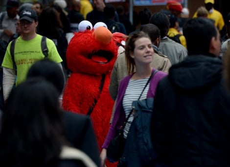 Toeristen in New York moeten dezer dagen niet gek opkijken als ze zien hoe de politie in het centrum van de stad Elmo, Cookie Monster of Spider-Man in de boeien slaat. De stad is de overlast namelijk zat van mensen die zich in een pak van de bekende tv-helden hullen en zogenaamd voor de lol op de foto gaan met toeristen. Veel van de artiesten blijken zich alleen maar te verkleden om bezoekers soms op agressieve manier geld af te troggelen en dat is niet de bedoeling. De politie is daarom een actie begonnen om dat de kop in te drukken, meldde de Britse krant The Guardian woensdag. Incident met Spider-Man Met de boosheid van een Spider-Man bereikte het slechte gedrag onlangs een piek. Hij sloeg een politieman afgelopen zaterdag op de neus. De agent wilde een ruzie beëindigen van Spider-Man met een vrouw die hem 1 dollar had gegeven. Dat was niet genoeg naar de smaak van de verklede superheld. Hij accepteerde alleen briefjes van 5, 10 of 20, zei hij. Na de stomp op de neus werd Spider-Man in de boeien geslagen. Eerder waren er al klachten over een Koekiemonster die een 2-jarig jongetje zou hebben geduwd, een Elmo die anti-semitische teksten uitkraamde en een man verkleed als Woody uit Toy Story die vrouwen betastte. Kun je dit reguleren? "Het is te ver gegaan'', vindt burgemeester Bill de Blasio. "Het is tijd om stappen te nemen om dit te reguleren." Juristen zetten vraagtekens bij de actie van de politie. Zij wijzen erop dat zij als straatartiesten beschermd worden door wet op de vrijheid van meningsuiting. "Als politici oproepen om mensen in een kostuum te reguleren, is dat zinloos", zegt Jonathan Turley, rechtsgeleerde aan George Washington University tegenover The Guardian. "Je hebt mensen op Wall Street die de wet dan overtreden, and mensen in Armani-pak onderwerpen we ook niet aan speciale regels." Immigranten De mensen in de pakken van superhelden en andere bekende figuren zijn doorgaans immigranten die de Engelse taal niet machtig zijn. Ze werken een uur of zeven achter elkaar en verdienen zo'n 50 tot 250 dollar per dag. Lees ook dit indringende verslag op Business Insider van de Colombiaanse fotografe Joana Toro, die anderhalf jaar lang verkleed als Hello Kitty op Times Square doorbracht. Zo werd ze vrienden met enkele collega-verkleders en kreeg ze een inkijkje in de soms schimmige wereld van de superhelden. Bron: Z24/ANP