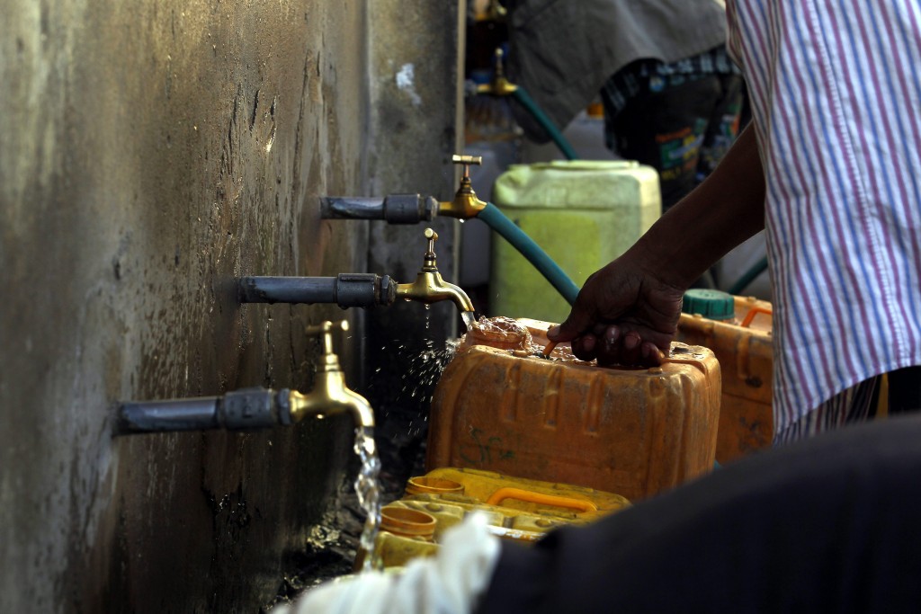 Jemenieten vullen jerrycans met water bij een donatiepunt in de hoofdstad Sana'a. Foto: EPA