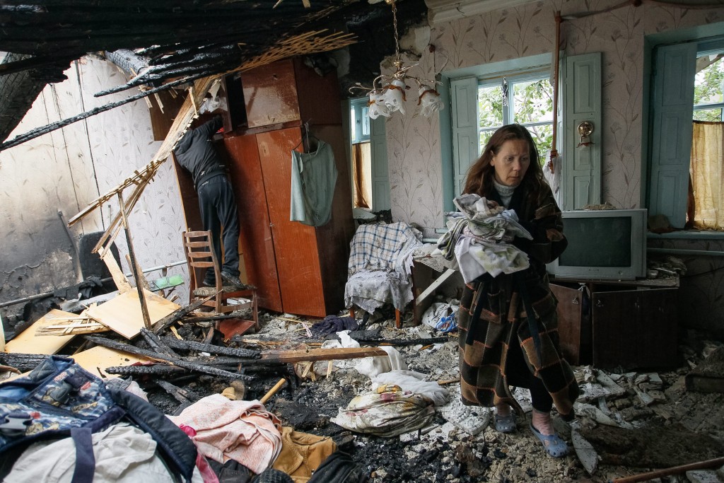Een vrouw ruimt puin in haar huis in Donetsk, na een recent bombardement, 9 juni 2016. De oorlog in Donbass, het oosten van Oekraïne, gaat nog steeds door. Foto: EPA