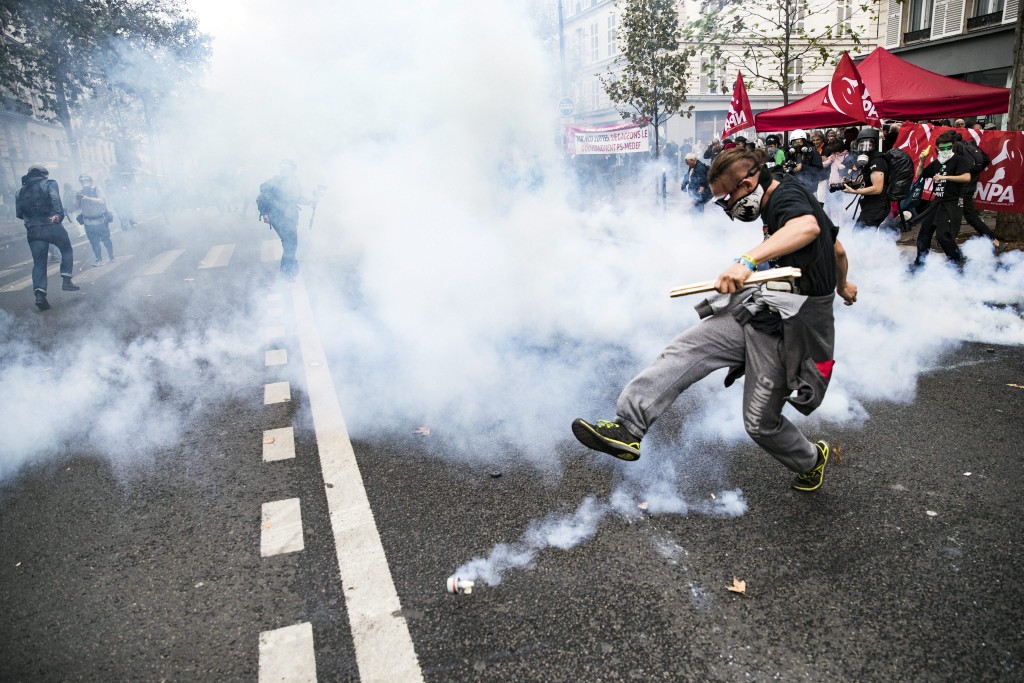 Een demonstrant schopt een traangasgranaat weg tijdens demonstraties tegen een nieuwe arbeidswet in Parijs, 15 september 2016. Foto: EPA