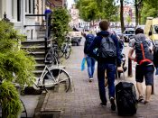 2016-06-16 11:24:14 AMSTERDAM - Toeristen met rolkoffers op de grachten in Amsterdam. Rolkoffers zijn een van de problemen van toenemende populariteit van AirBnB. ANP KOEN VAN WEEL