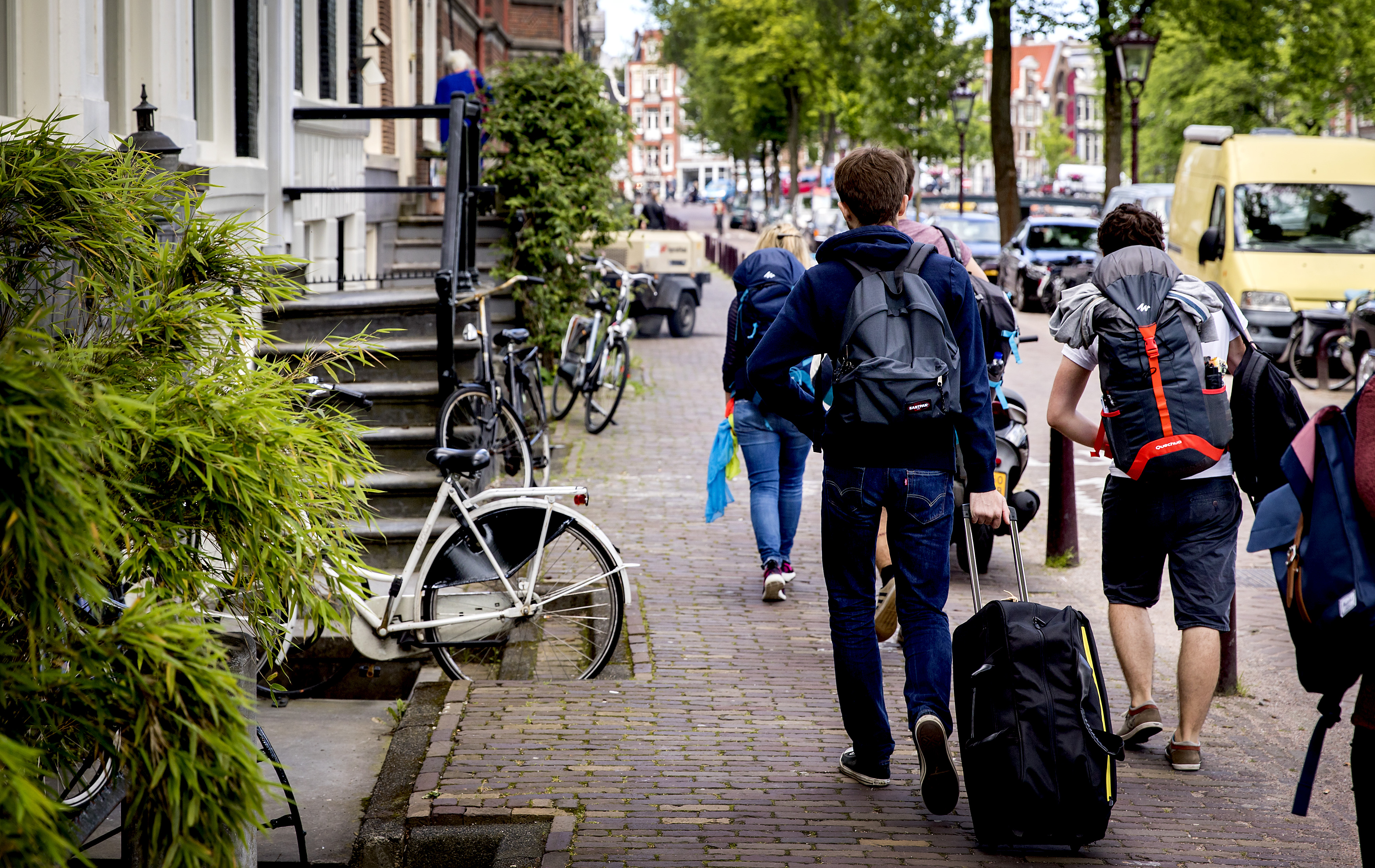 2016-06-16 11:24:14 AMSTERDAM - Toeristen met rolkoffers op de grachten in Amsterdam. Rolkoffers zijn een van de problemen van toenemende populariteit van AirBnB. ANP KOEN VAN WEEL