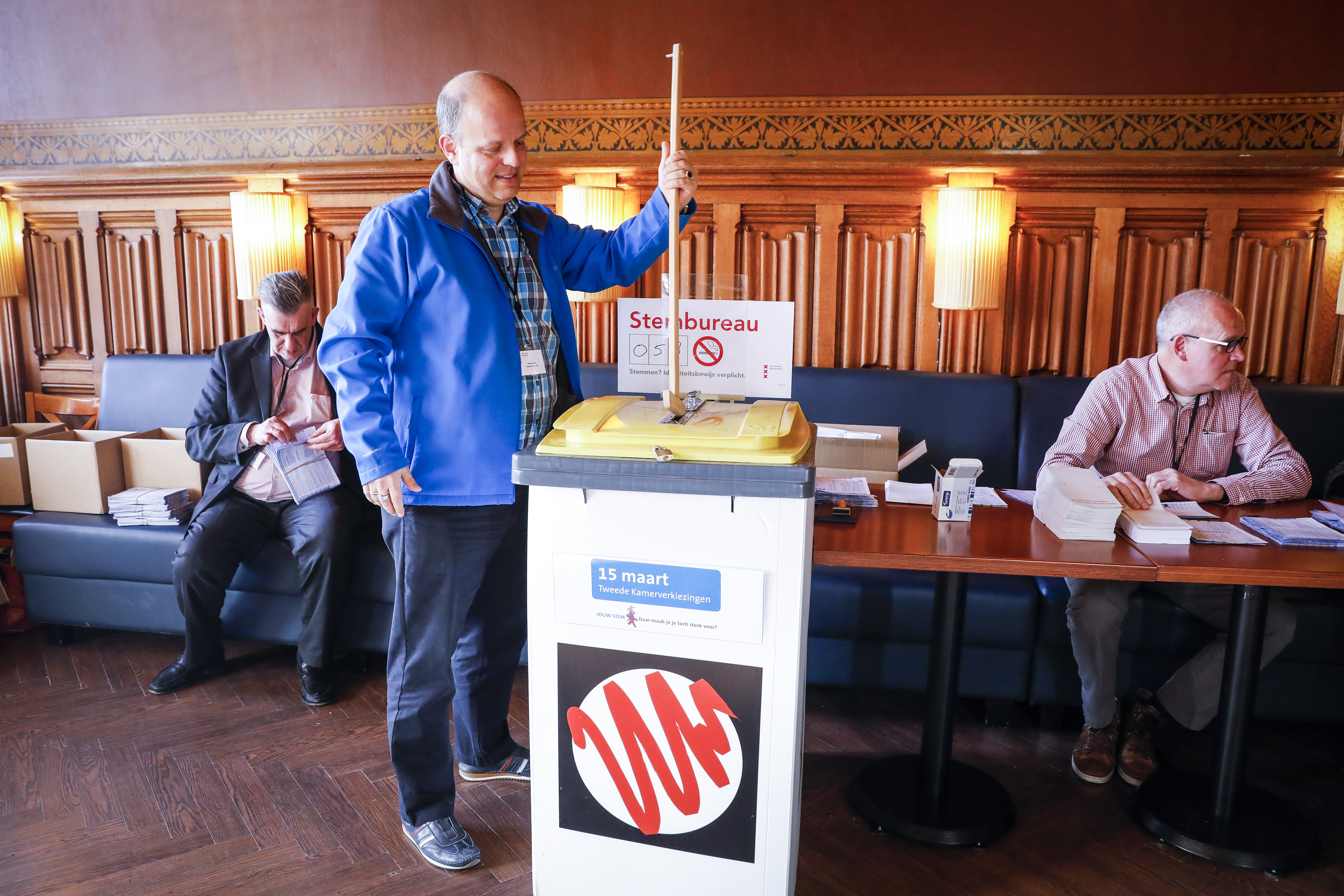 In dit Amsterdamse stembureau stampt een van de medewerkers de stemmen aan. Foto: ANP