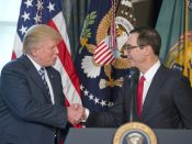 Donald Trump schudt de hand van zijn minister van Financiën, Steven Mnuchin.