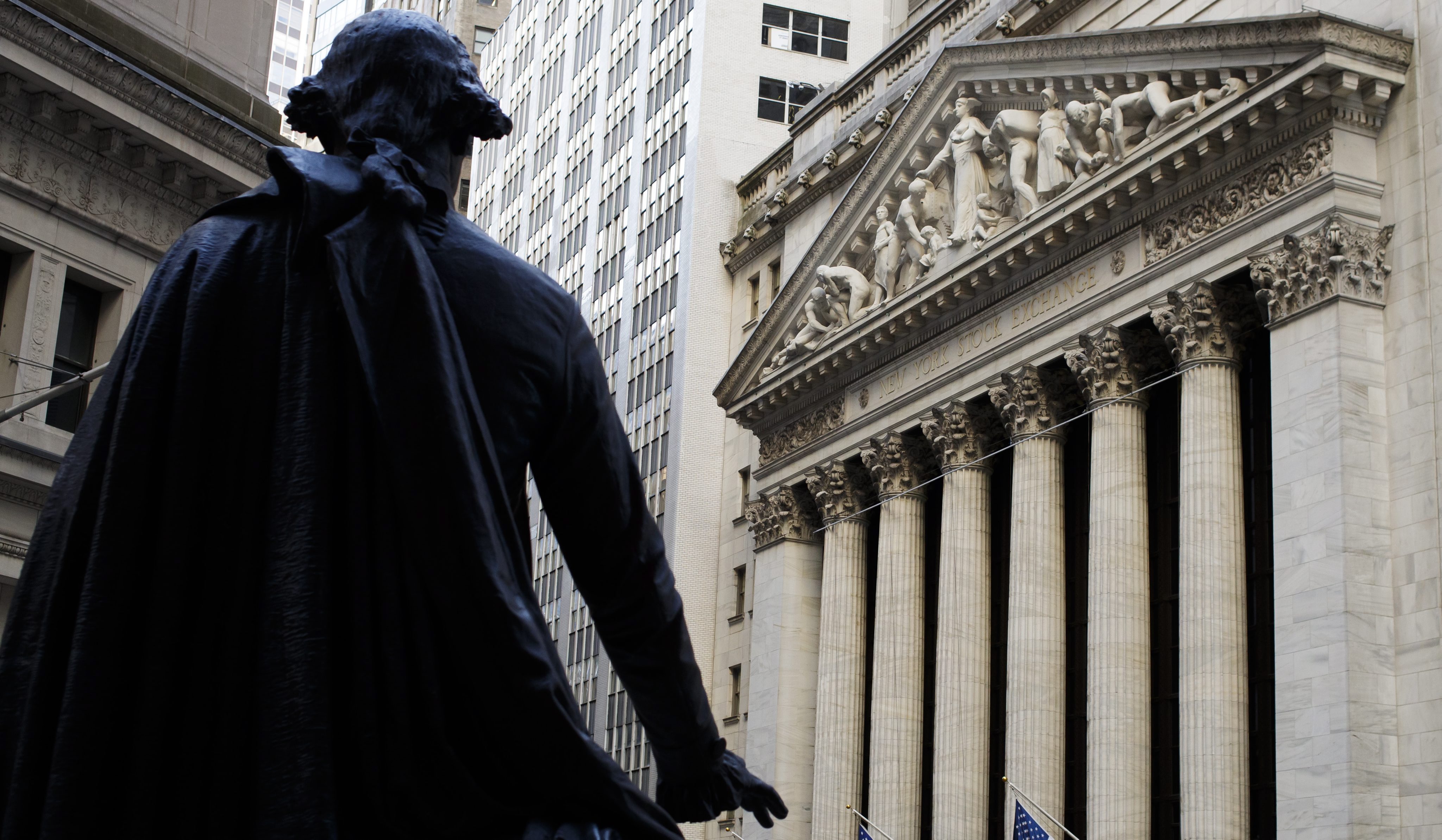 2017-01-25 16:54:26 epa05750450 A view the New York Stock Exchange (NYSE) from Federal Hall with a statue of President George Washington in the foreground before the Closing Bell in New York, New York, USA, 25 January 2017. The Dow Jones Industrial Average (DJIA) closed over the 20,000 mark for the first time today. EPA/JUSTIN LANE