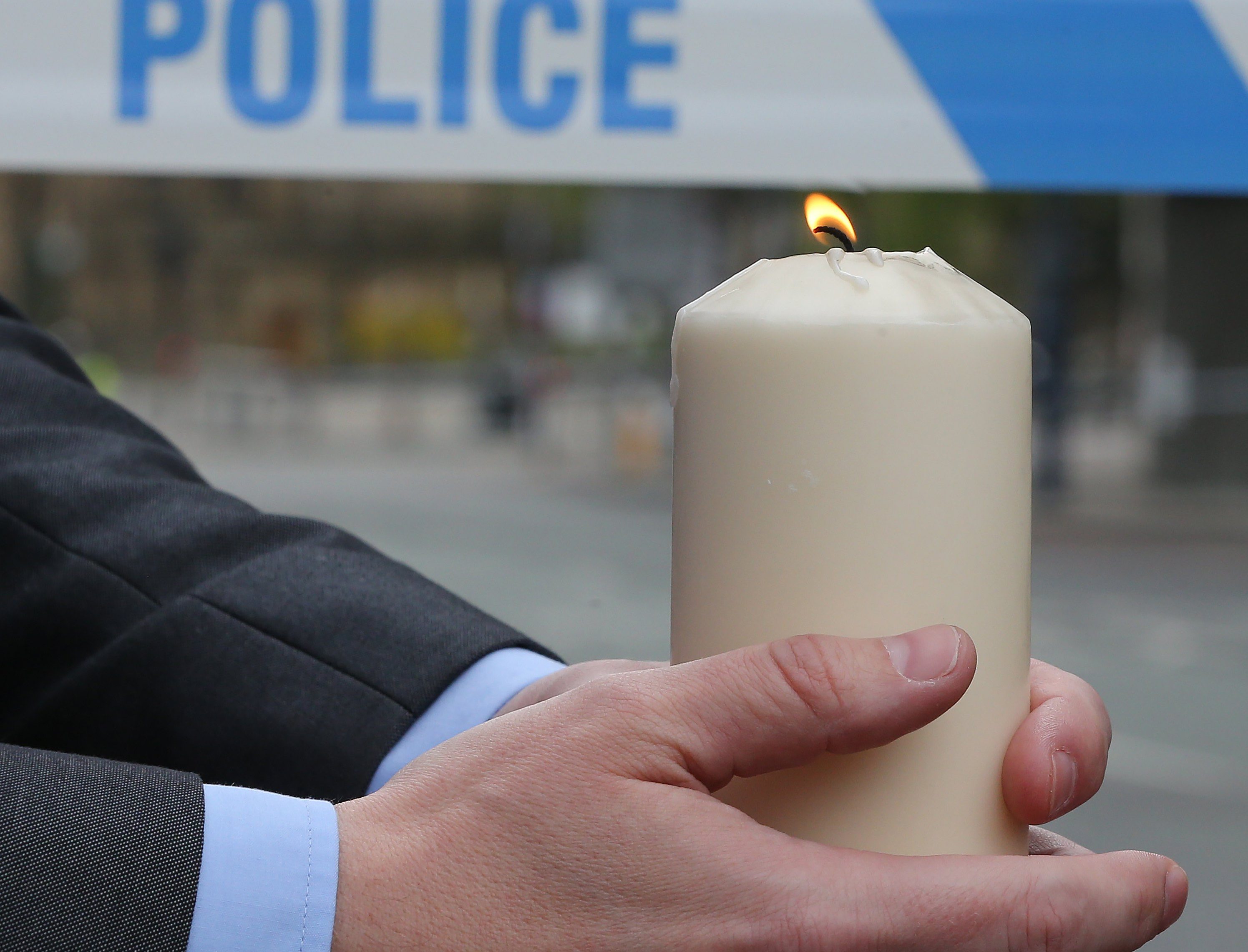 2017-05-23 05:04:36 epa05982975 A person holds a lit candle during a prayer session with the Dean of Manchester near the Manchester Arena in Manchester, Britain, 23 May 2017. According to a statement by the Greater Manchester Police, at least 22 people have been confirmed dead and around 59 others were injured, in an explosion at the Manchester Arena on the night of 22 May at the end of a concert by US singer Ariana Grande. Police believe that the explosion, which is being treated as a terrorist incident, was carried out by a single man using an improvised explosive device (IED), who was confirmed dead at the scene. EPA/NIGEL RODDIS