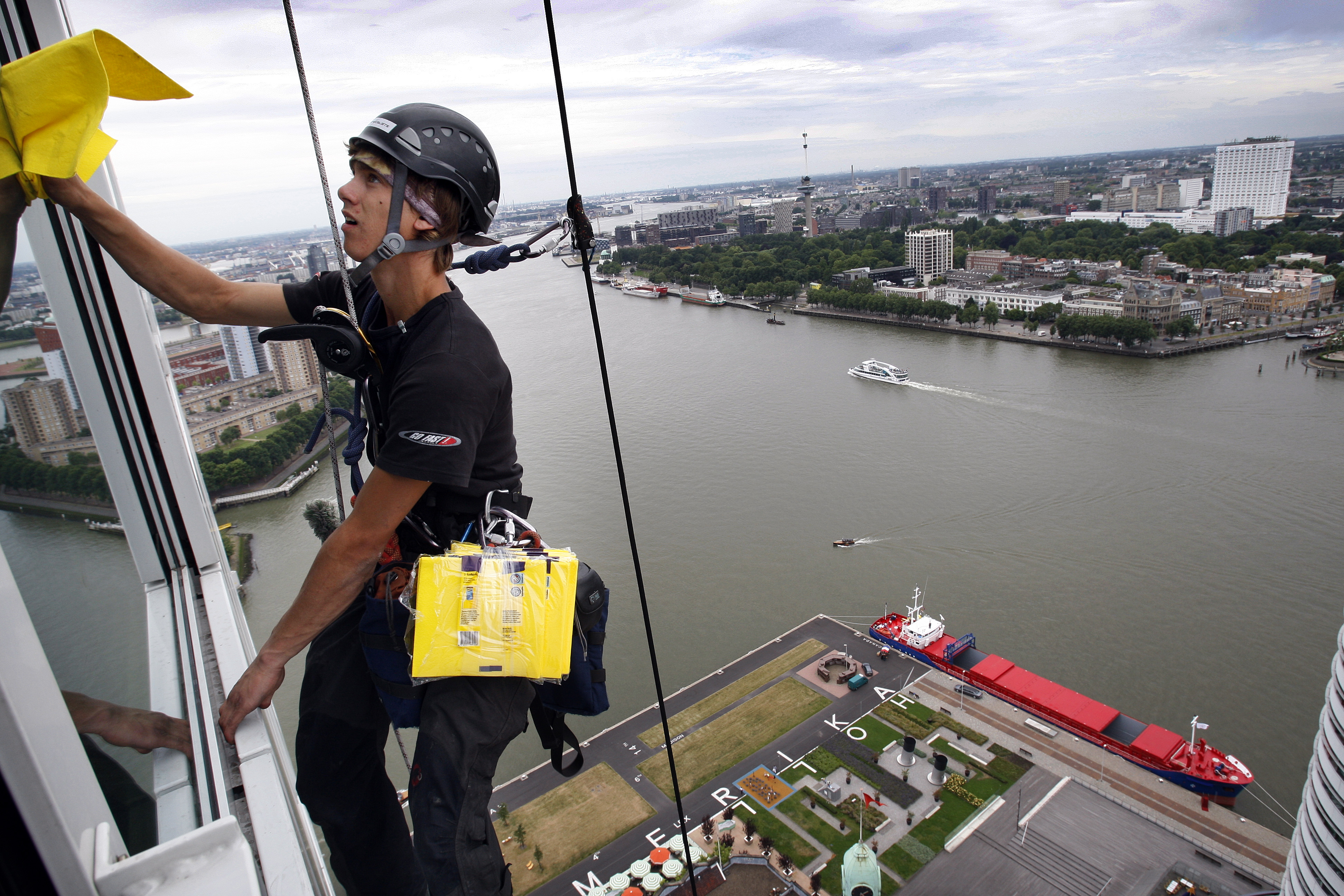 2008-07-05 16:36:24 ROTTERDAM - Medewerkers van Height Specialists wassen zaterdag de ramen van de Montevideo-toren aan de Kop van Zuid in Rotterdam. De woontoren is 155 meter hoog. Al abseilend wordt de klus geklaard. Het bedrijf is gespecialiseerd in industrieel klimmen. ANP PHOTO ROBERT VOS