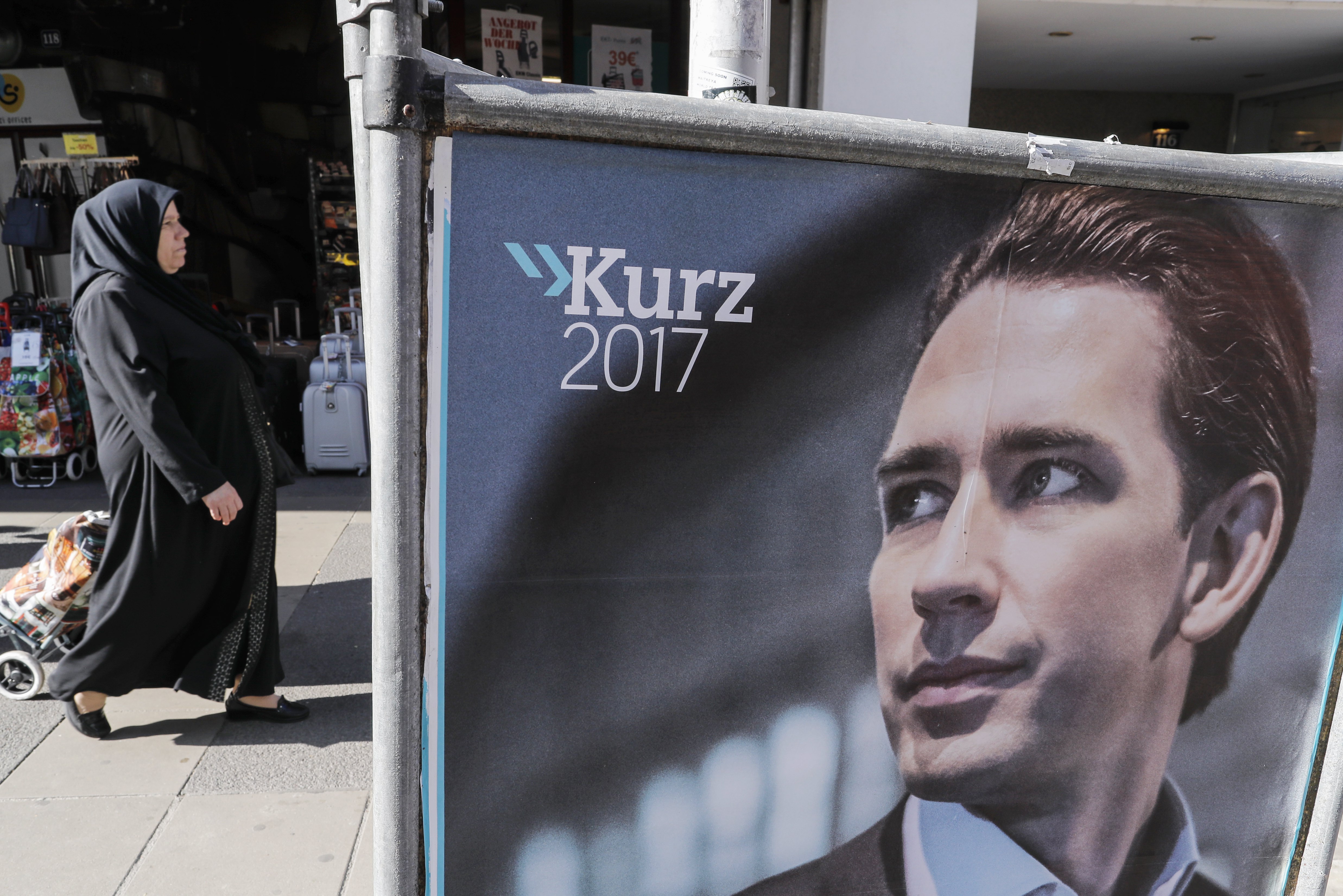 2017-10-14 12:17:47 epa06264888 A veiled woman passes an election poster of Austrian Foreign Minister Sebastian Kurz, the leader and top candidate of the Austrian Peoples Party (OeVP) in Vienna, Austria, 14 October 2017. The Austrian federal elections will take place on 15 October 2017. EPA/VALDRIN XHEMAJ