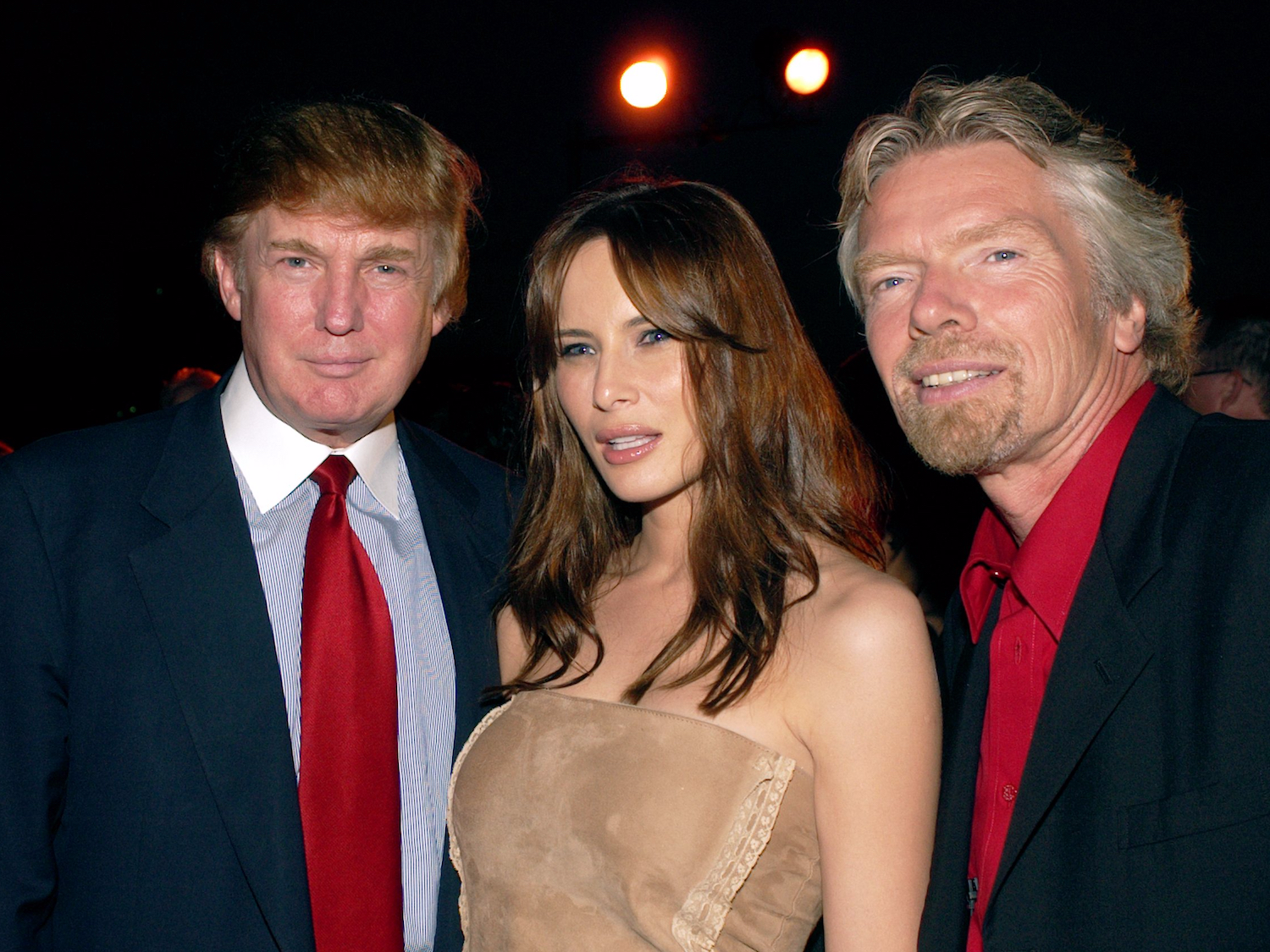 Donald Trump op een evenement van Virgin Mobile met zijn toekomstige vrouw Melania en Virgin-oprichter Richard Branson. Foto: Lawrence Lucier/Getty Images