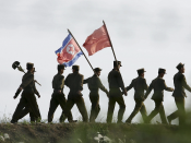 North Korean soldiers carrying the North Korean flag and shovels march after working at the farmland on the outskirts of the North Korean city of Sinuiju in this picture taken on October 18, 2006 in the Chinese border city of Dandong, Liaoning Province of China. North Korean soldiers carrying the North Korean flag and shovels march after working at the farmland on the outskirts of the North Korean city of Sinuiju in this picture taken on October 18, 2006 in the Chinese border city of Dandong, Liaoning Province of China.