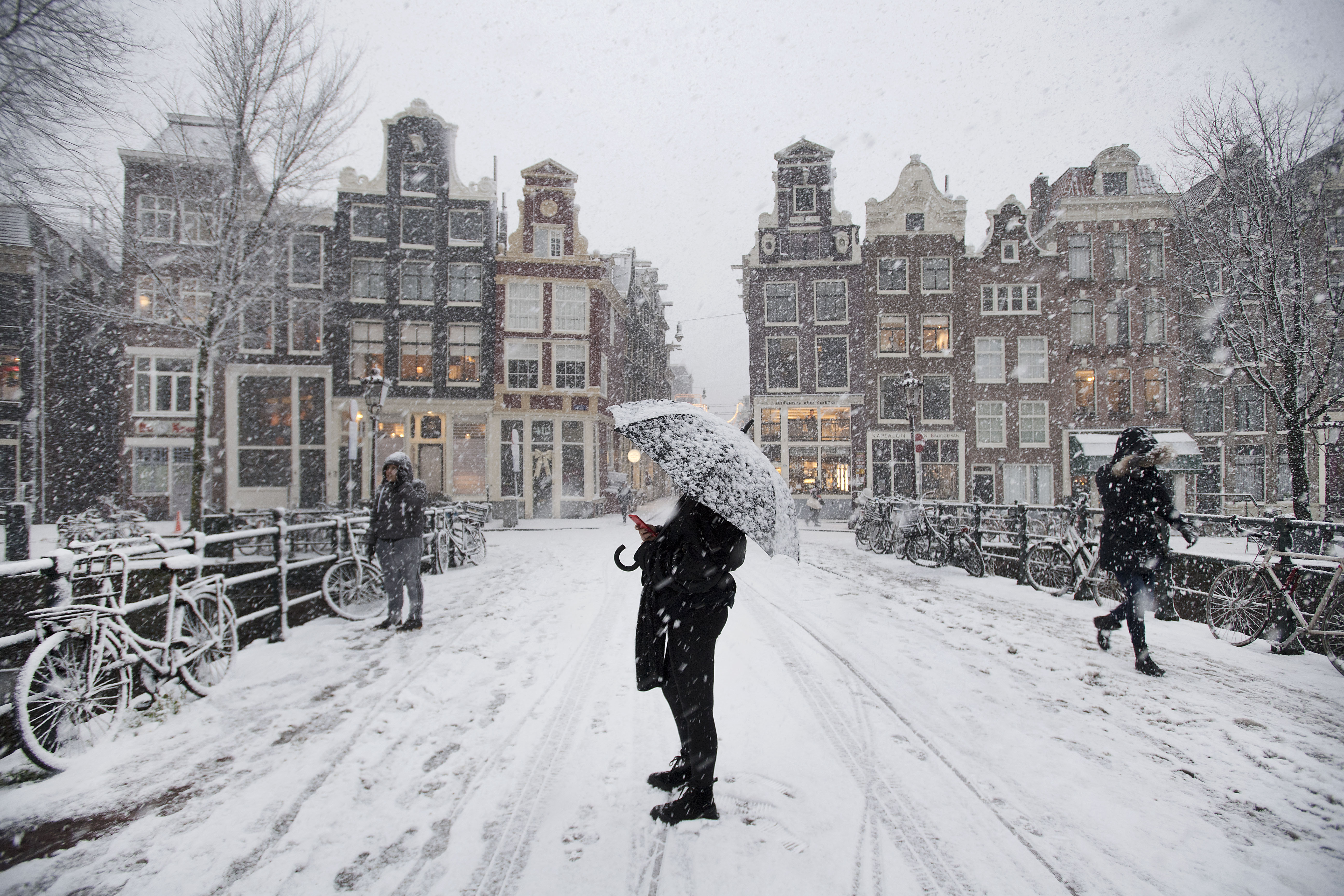 2017-12-11 16:58:12 AMSTERDAM - Een toeriste maakt een foto. Het KNMI heeft code rood afgegeven voor hevige sneeuwval. ANP OLAF KRAAK
