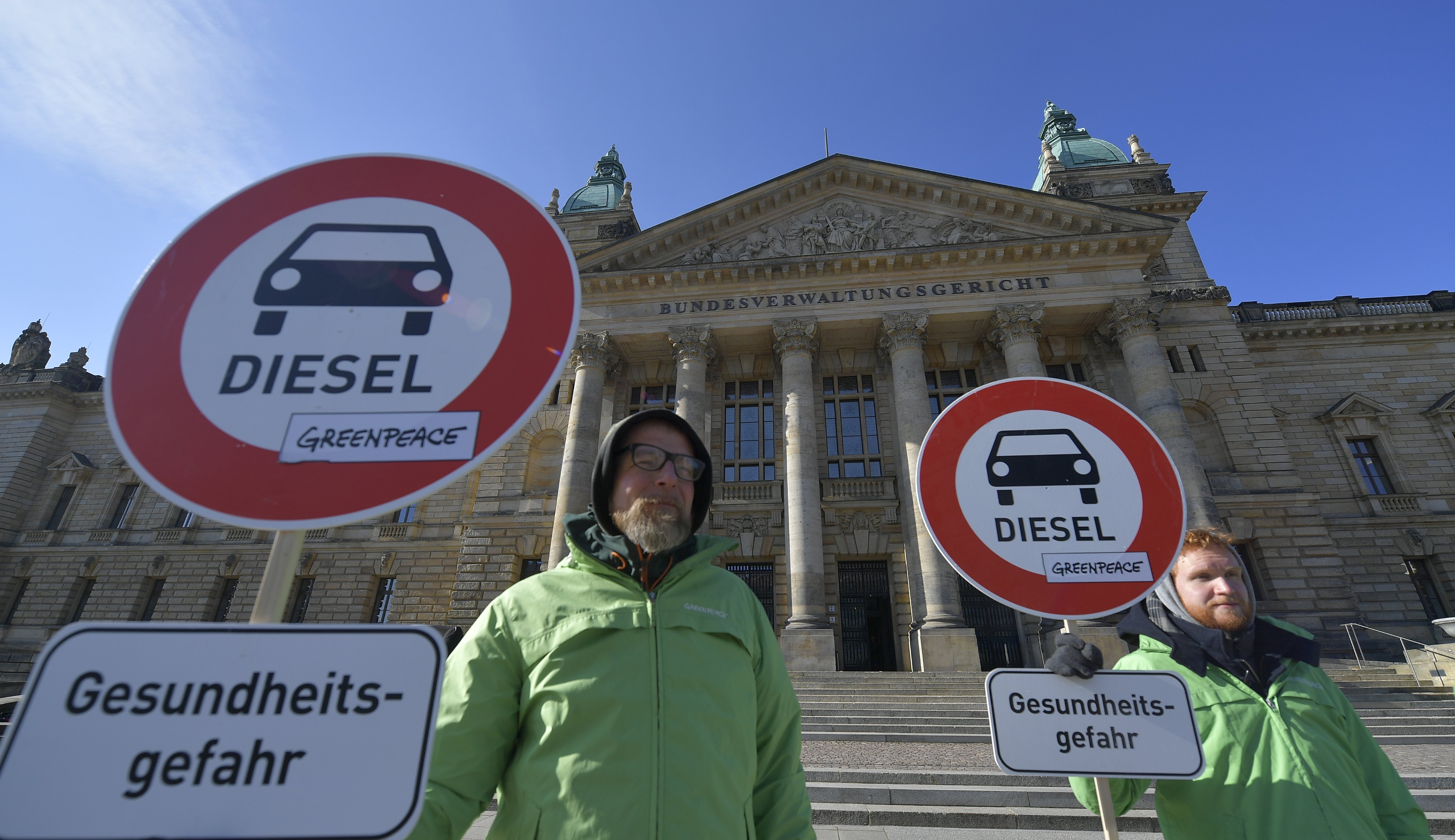 2018-02-27 12:00:24 epa06568203 Environmentalists with posters stand in front of the court building at the start of a hearing at the Federal Administrative Court prior to the judges' decision on banning Diesel engine powered vehicles from German cities when air pollution exceeds the permissible limits, in Leipzig, Germany, 27 February 2018. The court ruled that banning Diesel engine powered vehicles from innercity traffic in general is permissible but asked the cities to review their air quality requirements for proportionality. In 2017, some 70 German cities exceeded the EU limit for nitrogen oxide, which has been in force since 2010. Placard reads: 'Diesel Danger to the Health' EPA/MATTHIAS RIETSCHEL