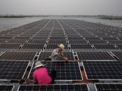 Arbeiders aan het werk op de zonnefarm nabij Huainan in China. Foto: Kevin Frayer/Getty Images