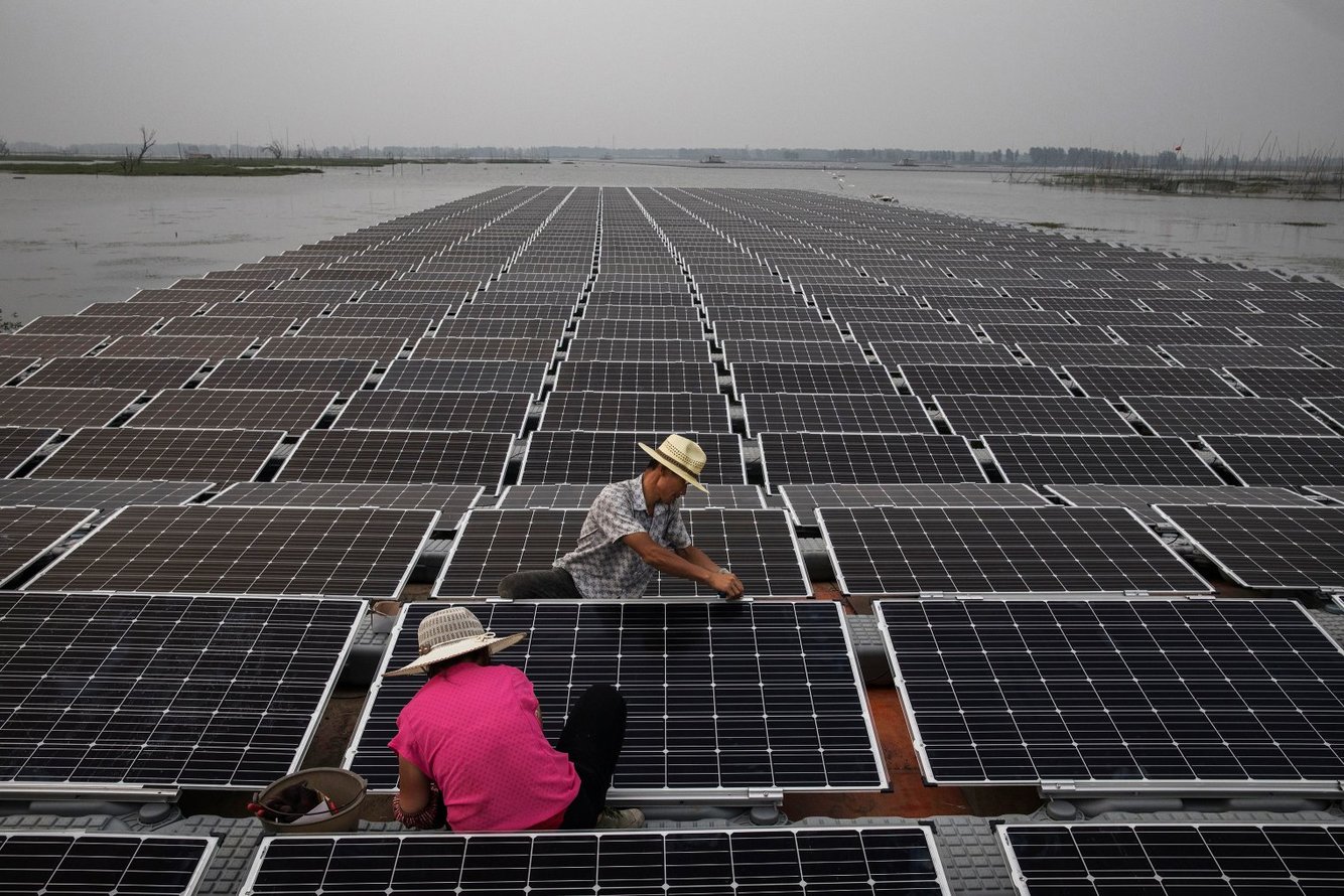 Arbeiders aan het werk op de zonnefarm nabij Huainan in China. Foto: Kevin Frayer/Getty Images