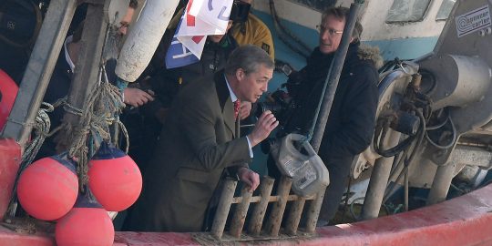 Voormalig UKIP-leider Nigel Farage gooit dode vis in de Theems.