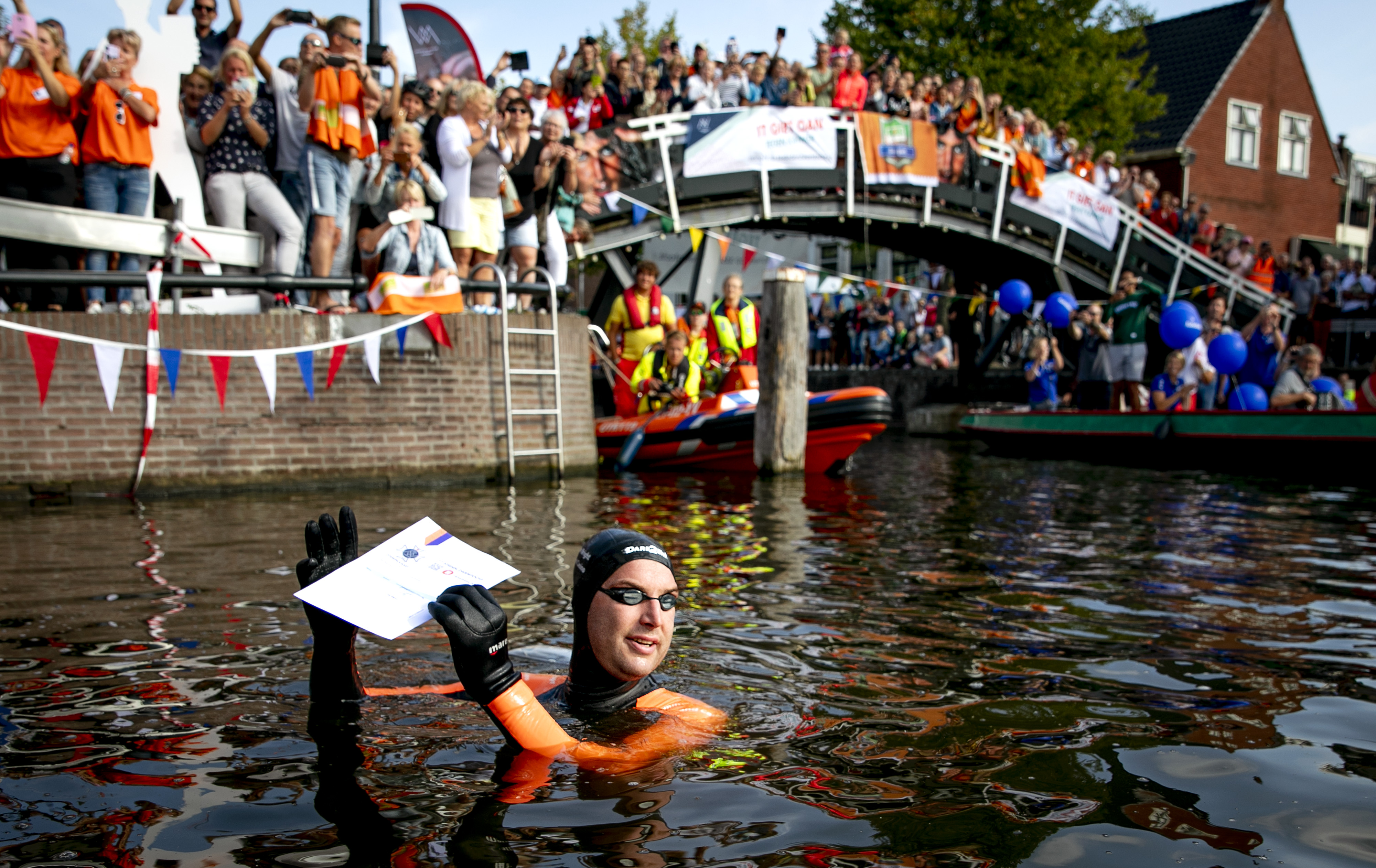 Maarten van der Weijden neemt tijdens zijn Elfstedentocht een donatie in ontvangst. Foto: ANP