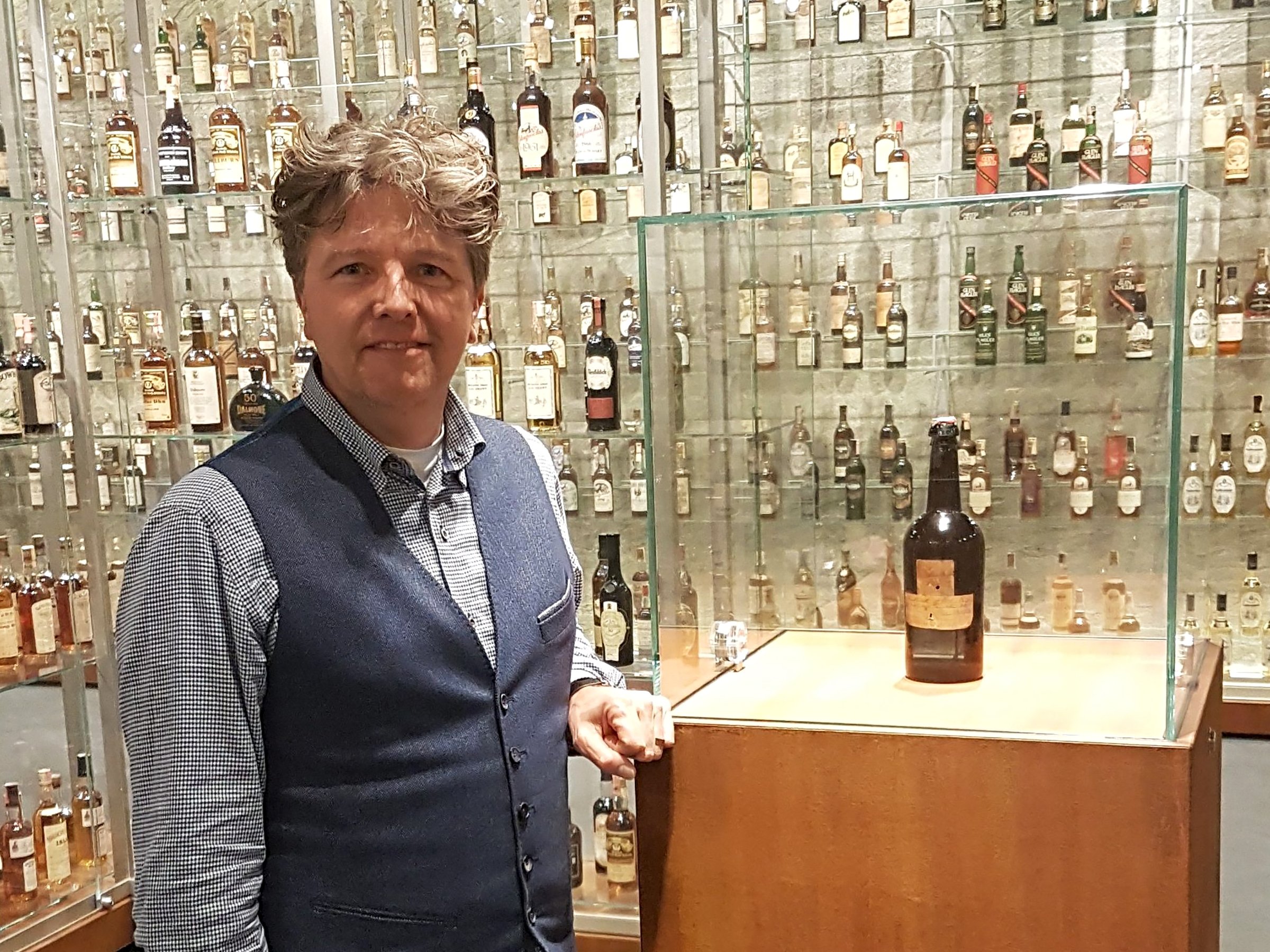 Paul van der Hulst, commercieel directeur bij SWI, toont de oudste fles in het Zagatti Museum in Sassenheim.