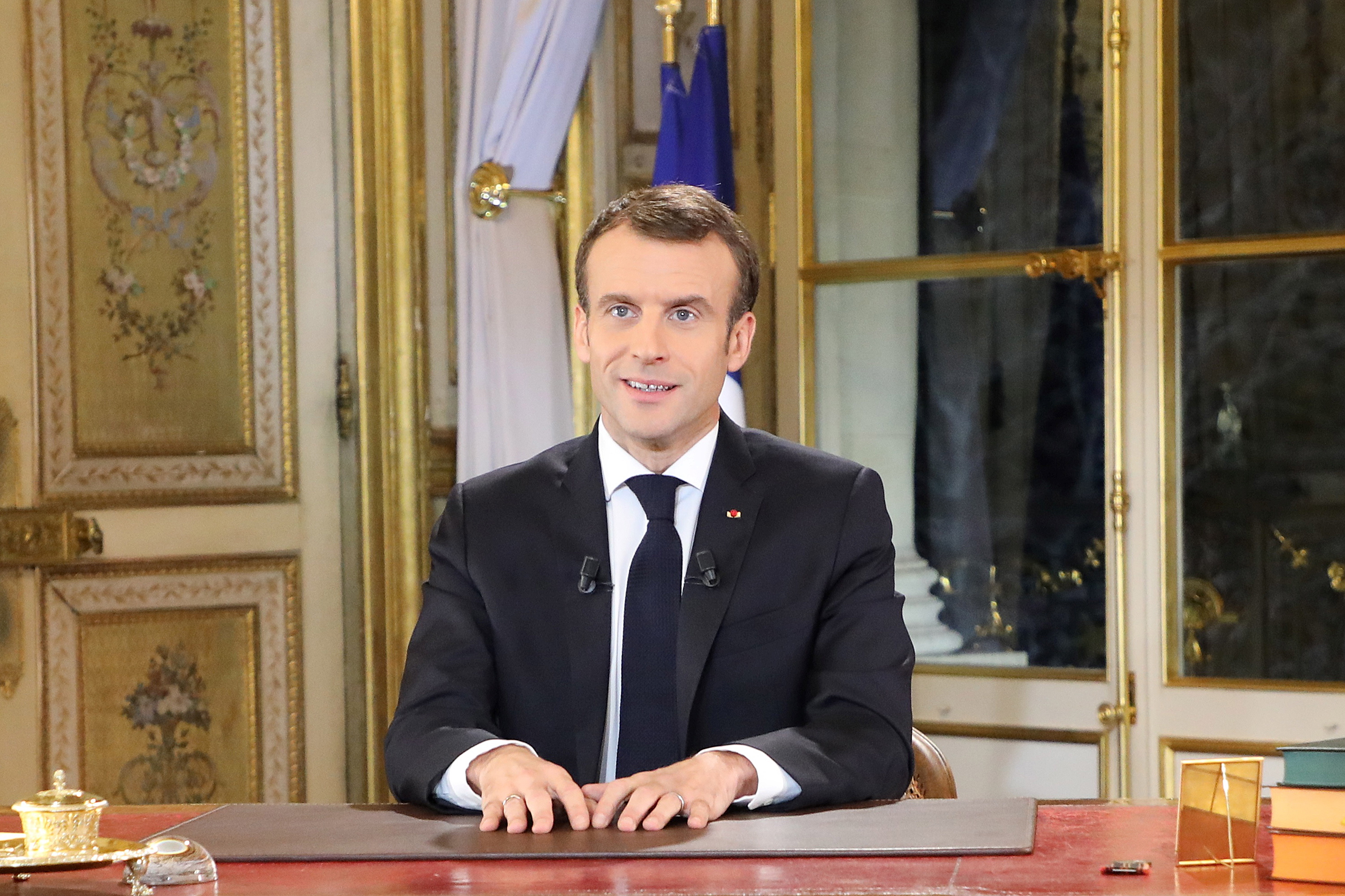 De Franse president Emmanuel Macron spreekt zijn land op nationale televisie toe vanuit het Elysée.