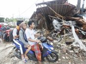 Bewoners rijden door het door de tsunami getroffen Pandeglang, Banten, Indonesië.