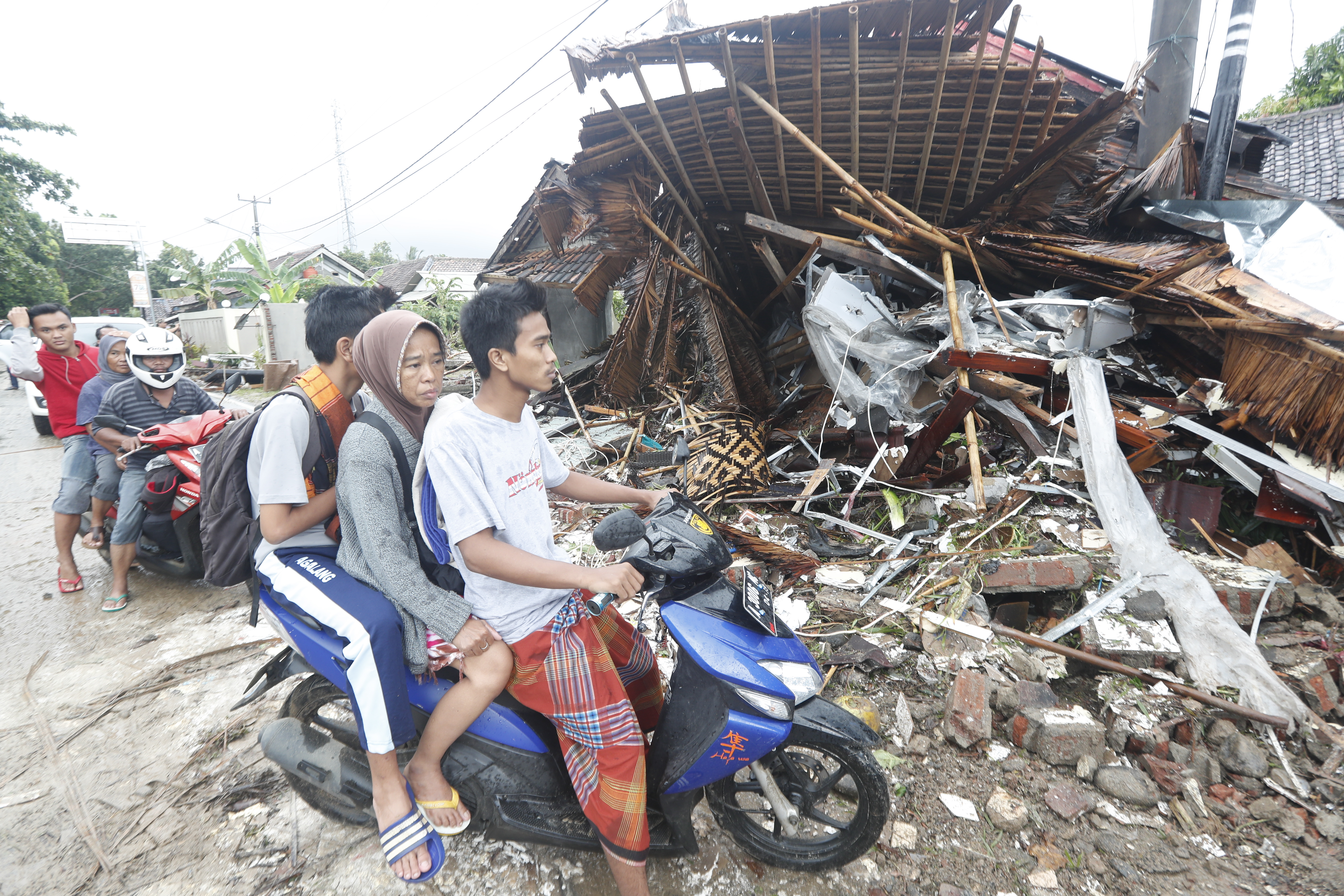Bewoners rijden door het door de tsunami getroffen Pandeglang, Banten, Indonesië.