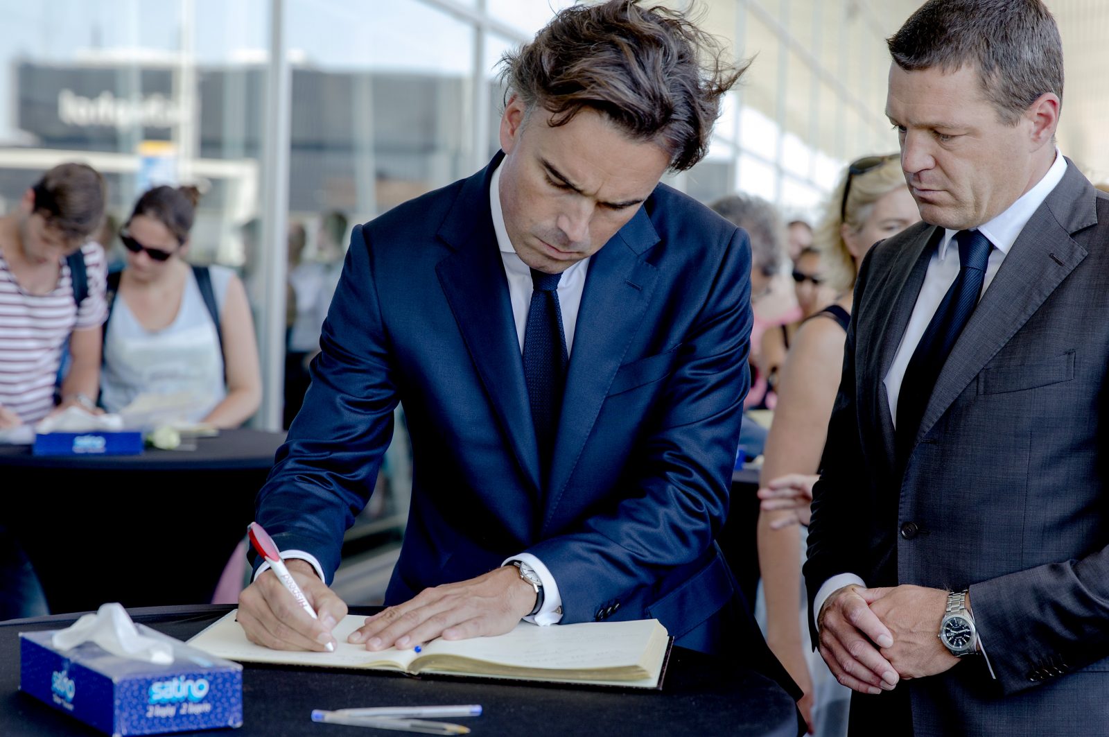 Camiel Eurlings (links) en Pieter Elbers tekenen het condoleanceregister op Schiphol na de aanslag op vlucht MH17 in juli 2014. Foto: ANP