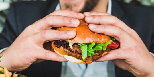 Een man eet een hamburger