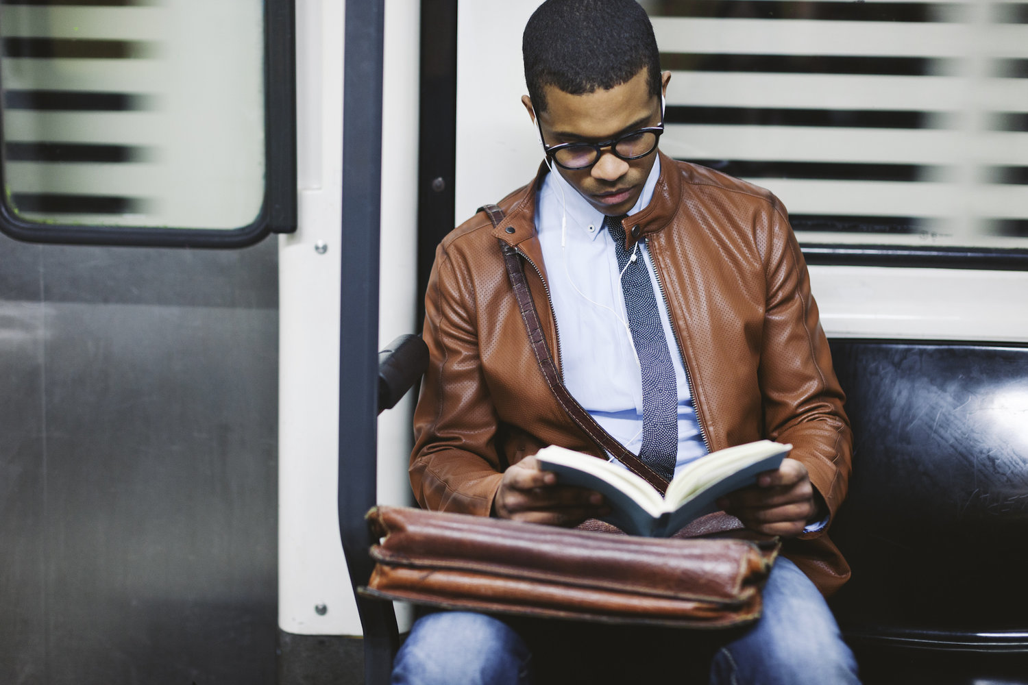 Businessman reading book on the subway train