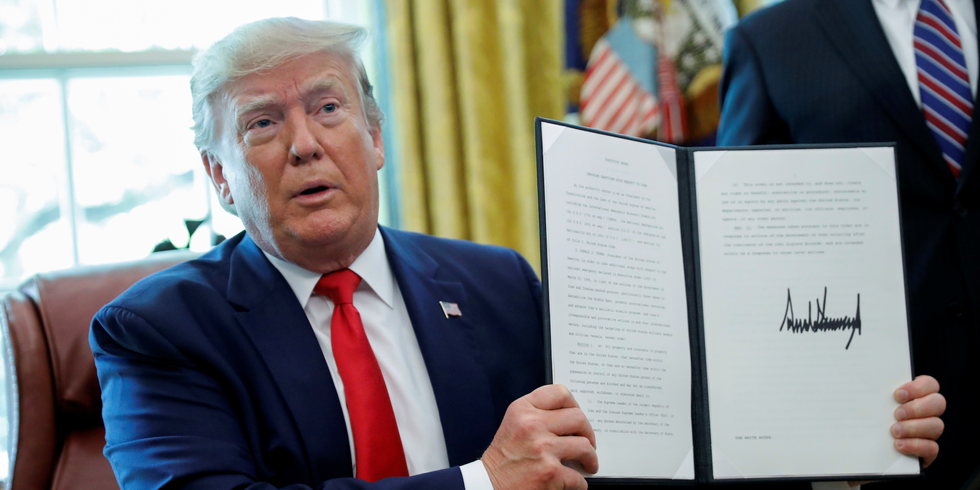 Foto Reuters. President Trump tekent een executive order