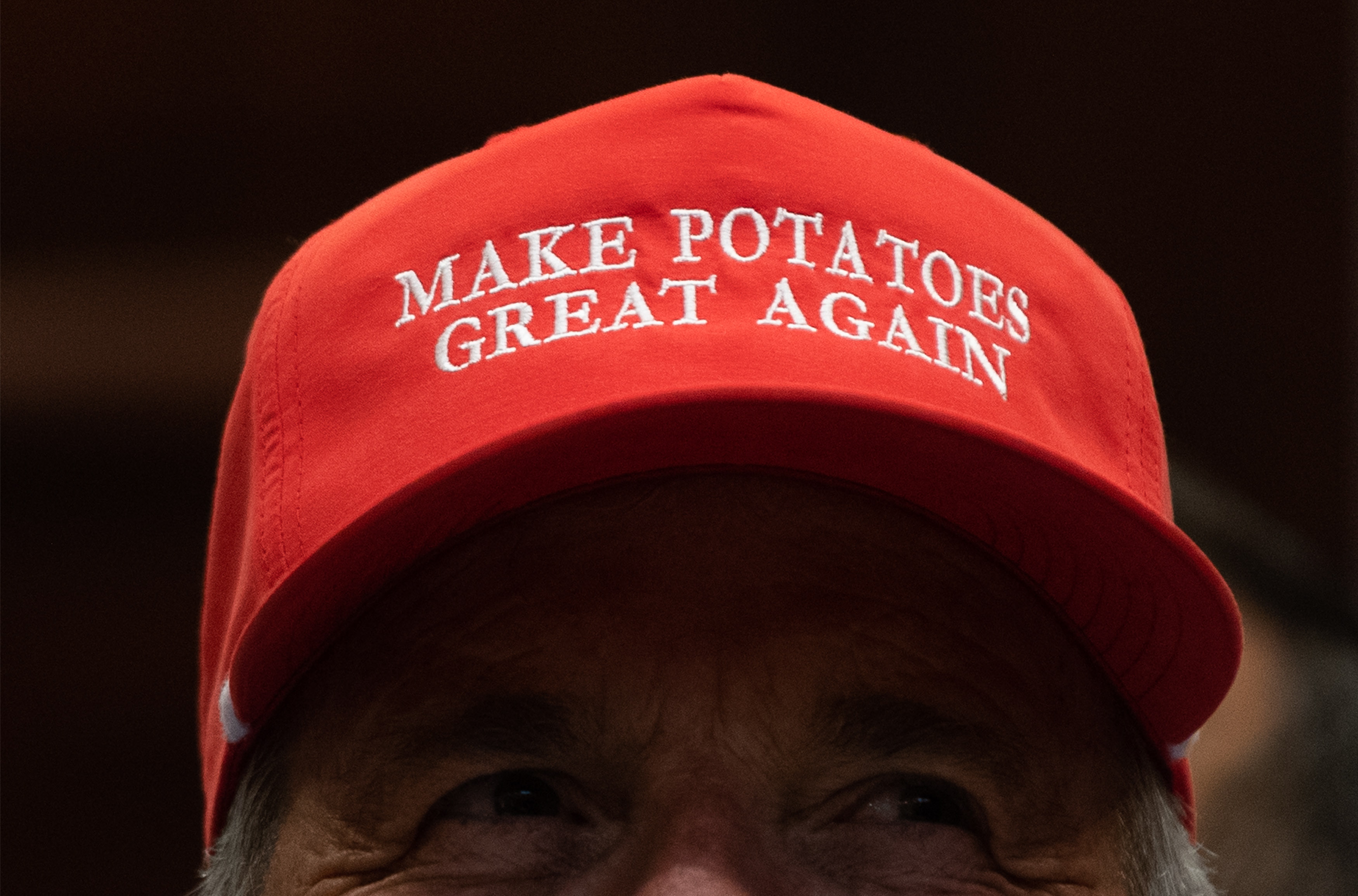 Een boer bij het Witte Huis met een pet met daarop een tekst die varieert op de bekende Trump-slogan 'Make America great again'.