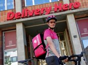 Een Foodora-bezorger voor het hoofdkantoor van Delivery Hero in Berlijn