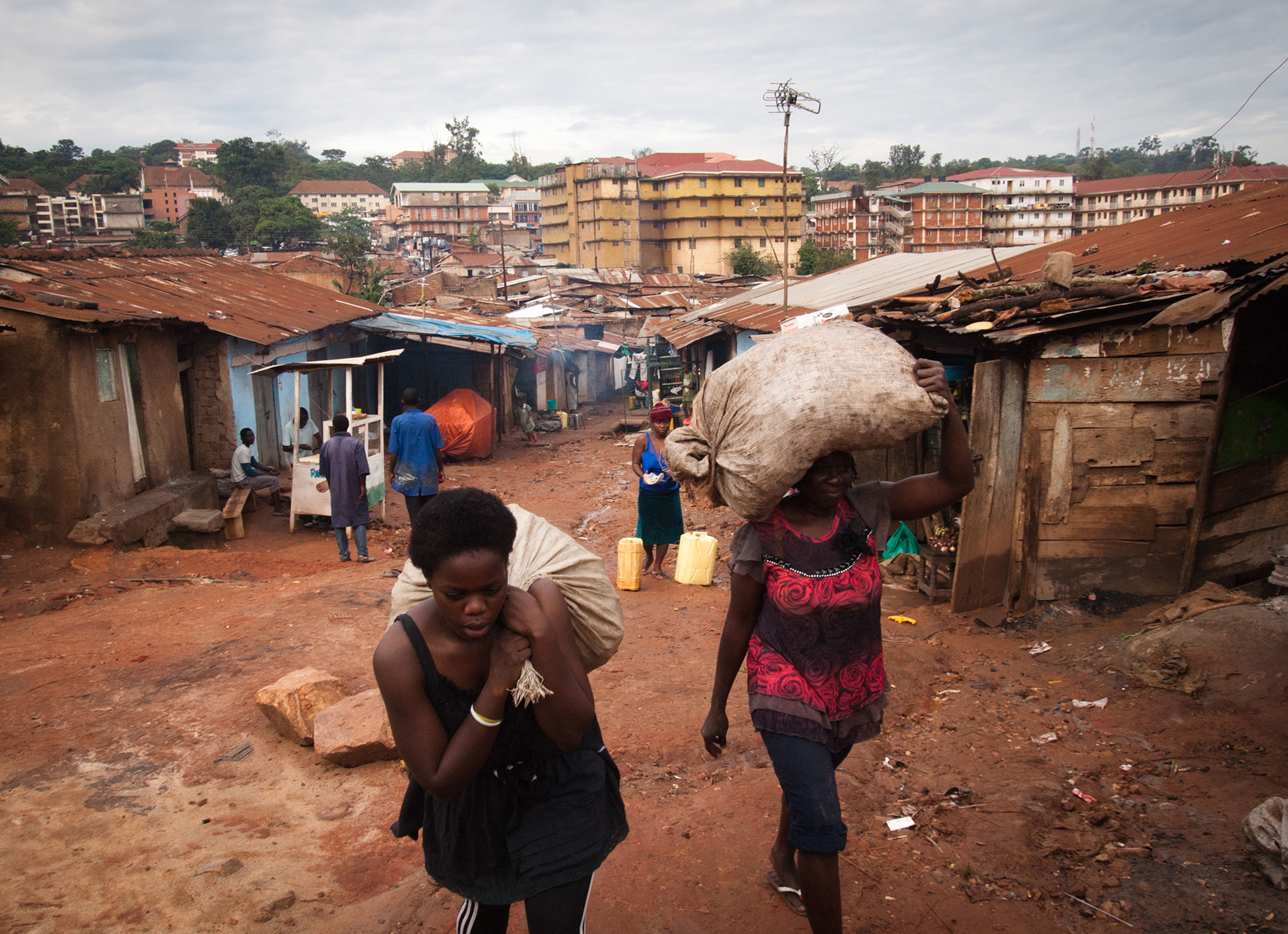 Vrouwen dragen zakken met bananenschillen in Oeganda.