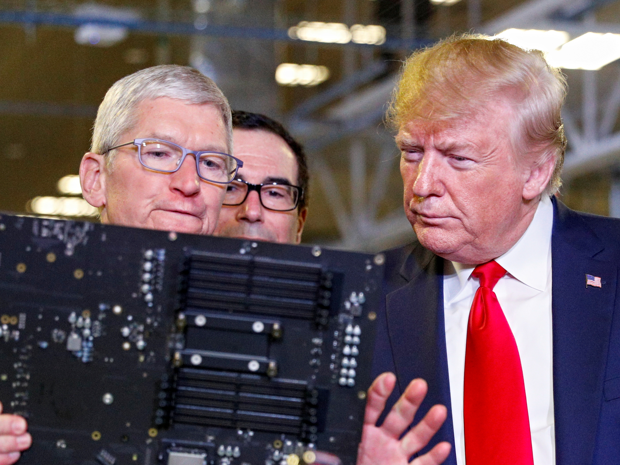 Apple-topman Tim Cook leidt president Donald Trump rond in de fabriek in Texas.