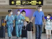 Passagiers en luchtvaartpersoneel dragen mondkapjes op de internationale luchthaven van Sri Lanka.