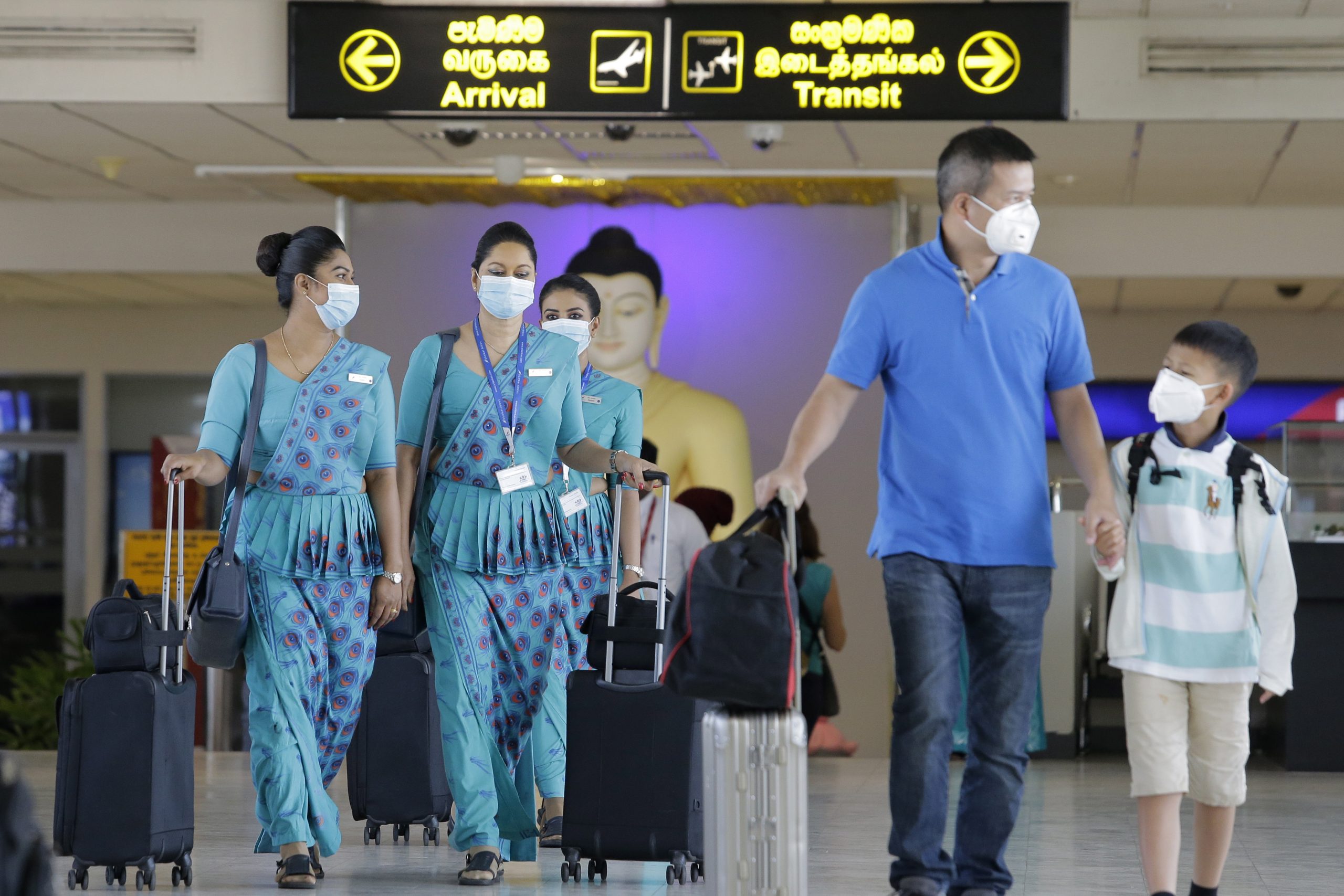 Passagiers en luchtvaartpersoneel dragen mondkapjes op de internationale luchthaven van Sri Lanka.