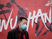 Een man in het Chinese Wuhan met een mondkapje tegen het coronavirus.