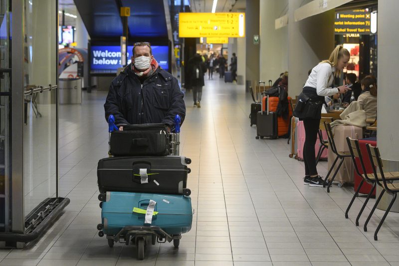 Passagier op Schiphol met een mondkapje