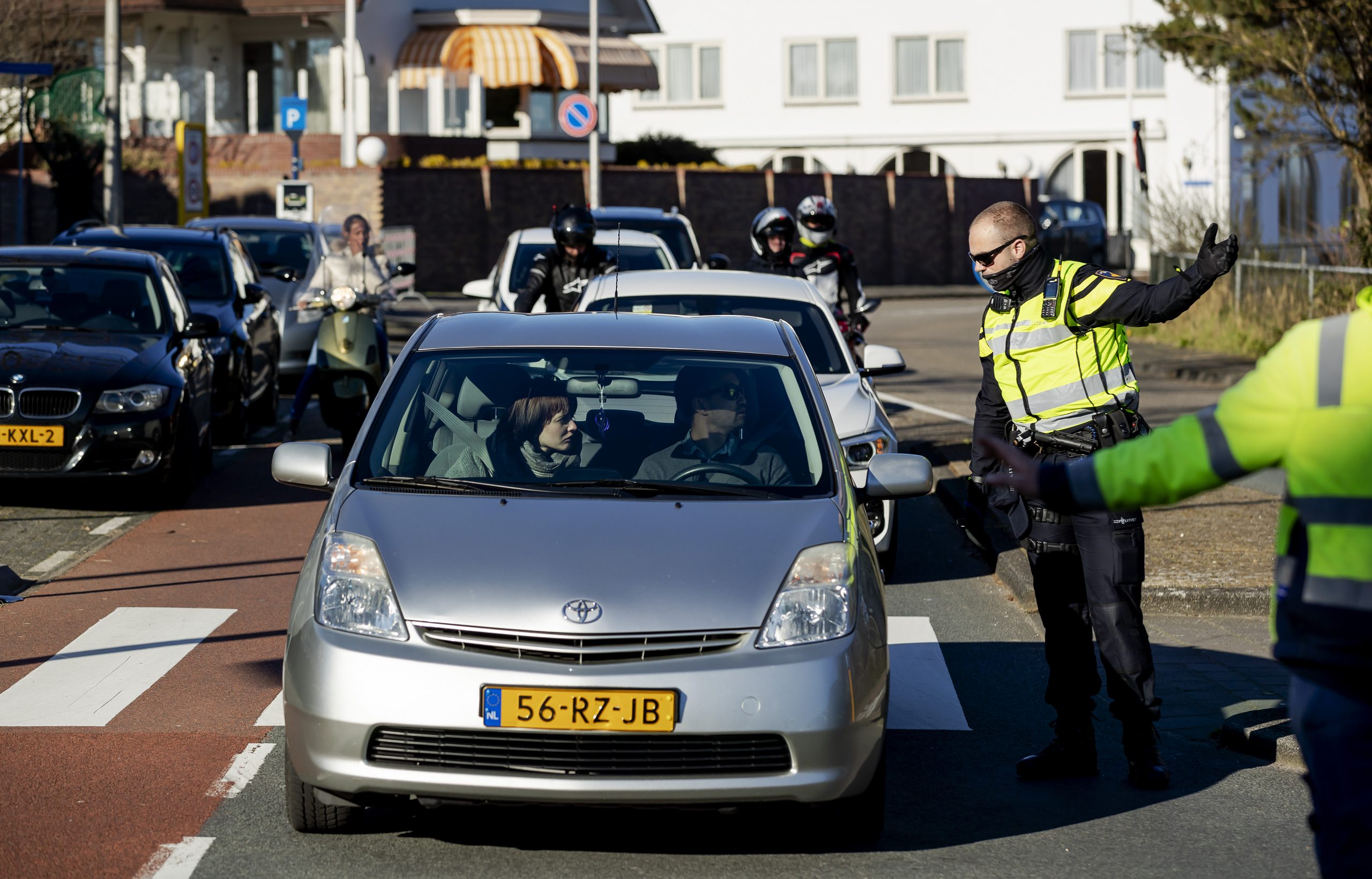 Politie agenten houden mensen tegen op de toegangswegen naar de boulevard en het strand van Noordwijk.