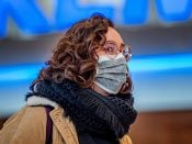 Een vrouw met een mondkapje op Schiphol