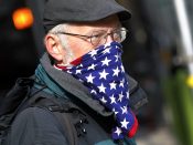 Een man draag een mondkapje met de Amerikaanse vlag erop