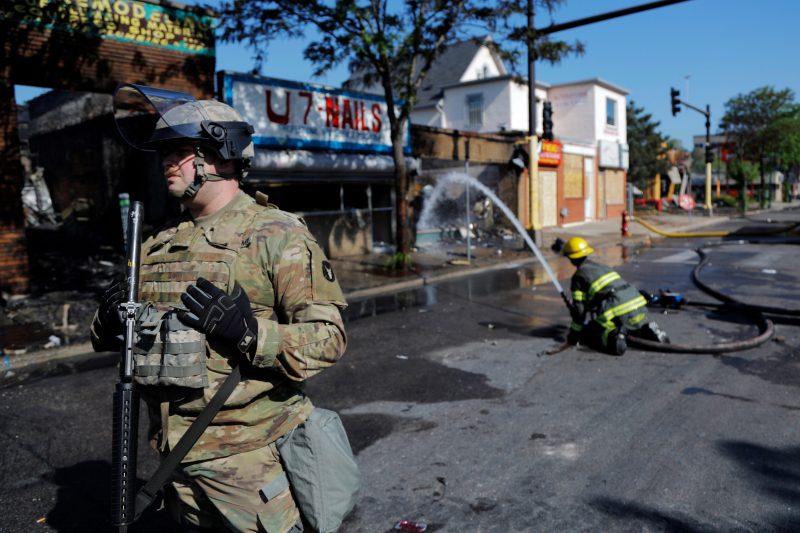 Members of the National Guard secure the area as firefighters continue to douse flames Saturday morning, May 30, 2020, in Minneapolis