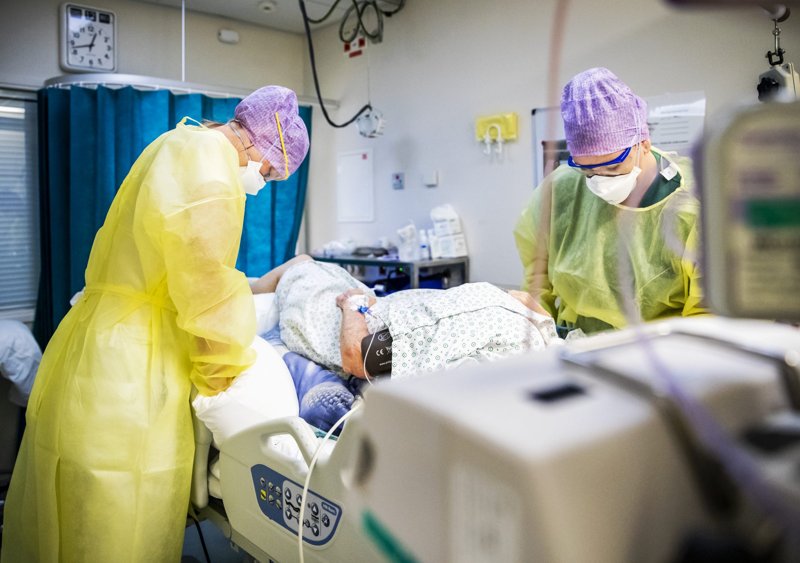 Zorgmedewerksters verlenen zorg aan een patient op de intensive care (van het HMC Westeinde ziekenhuis.