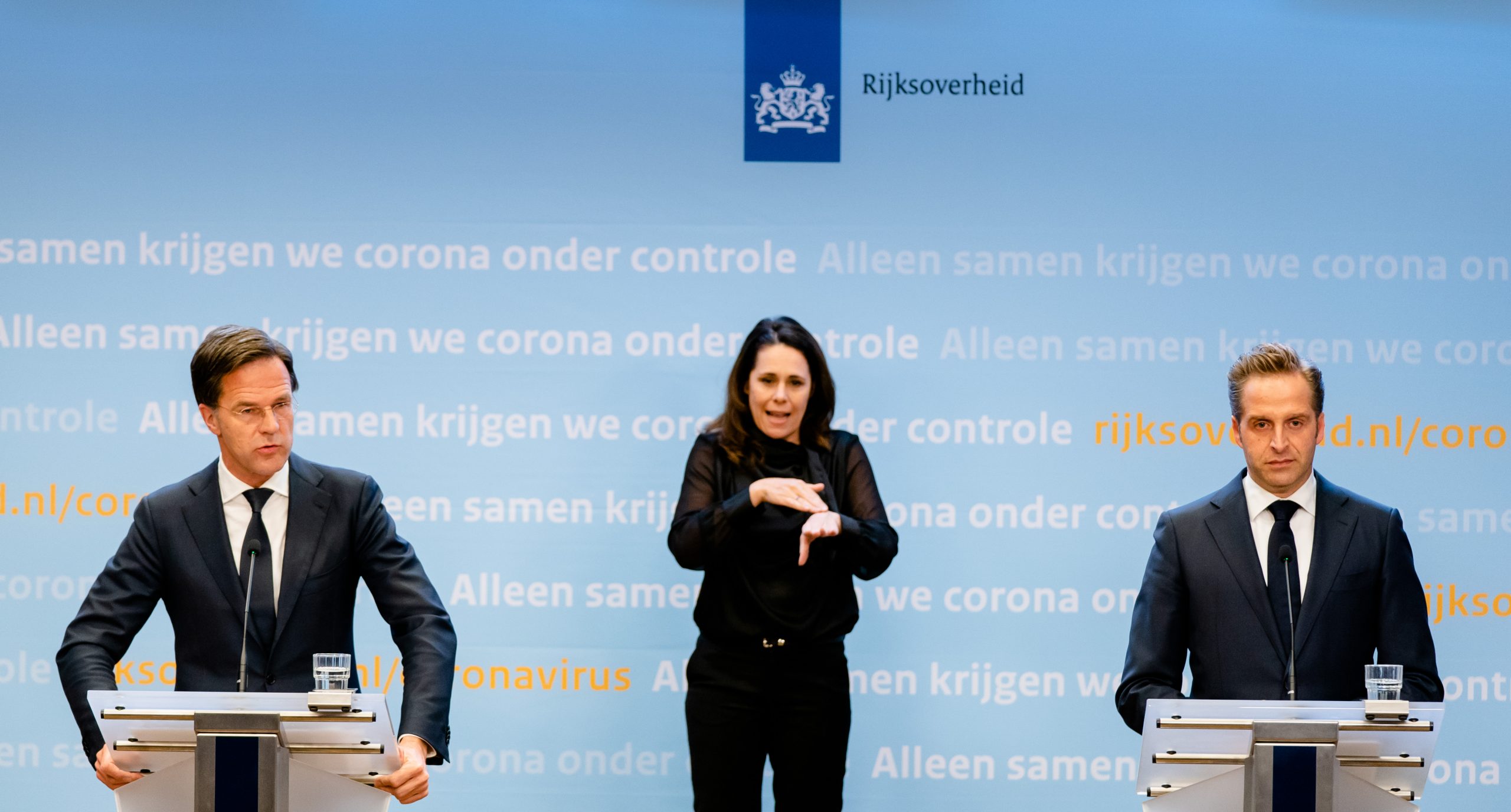 Minister Hugo de Jonge, premier Rutte en doventolk Irma Sluis tijdens een persconferentie over het coronavirus. Foto: ANP/Bart Maat