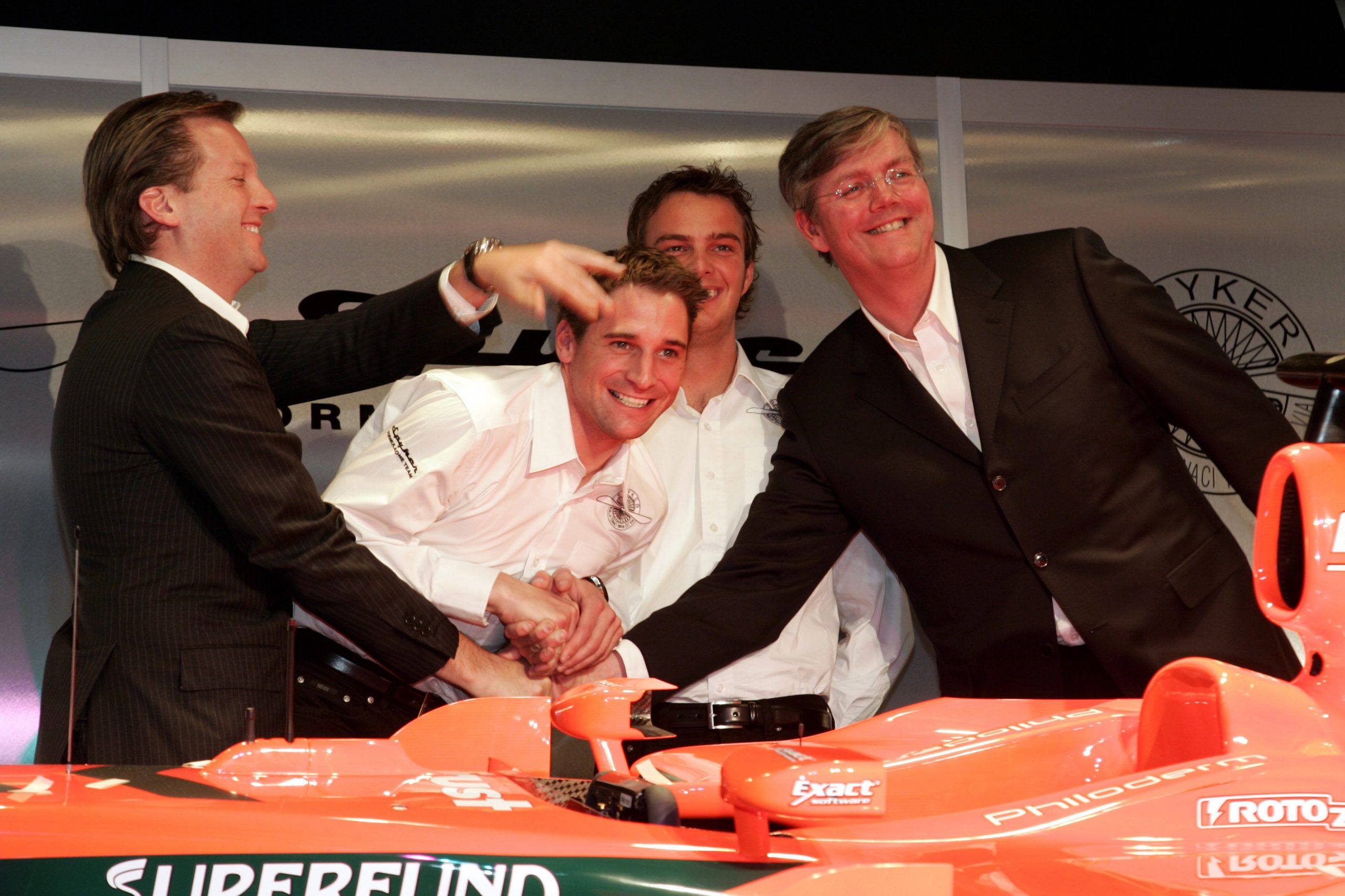 Michiel Mol, Christijan Albers, testrijder Giedo van der Garde en Victor Muller dollen bij een Formule 1-auto van Spyker. Foto: ANP/Diederik van der Laan