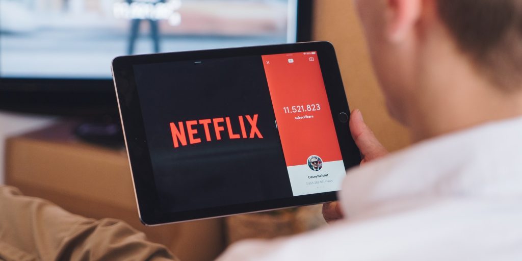 Een man kijkt Netflix op zijn tablet thuis op de bank
