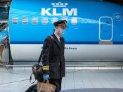 Een piloot (geen KLM) met mondkapje op luchthaven Schiphol.