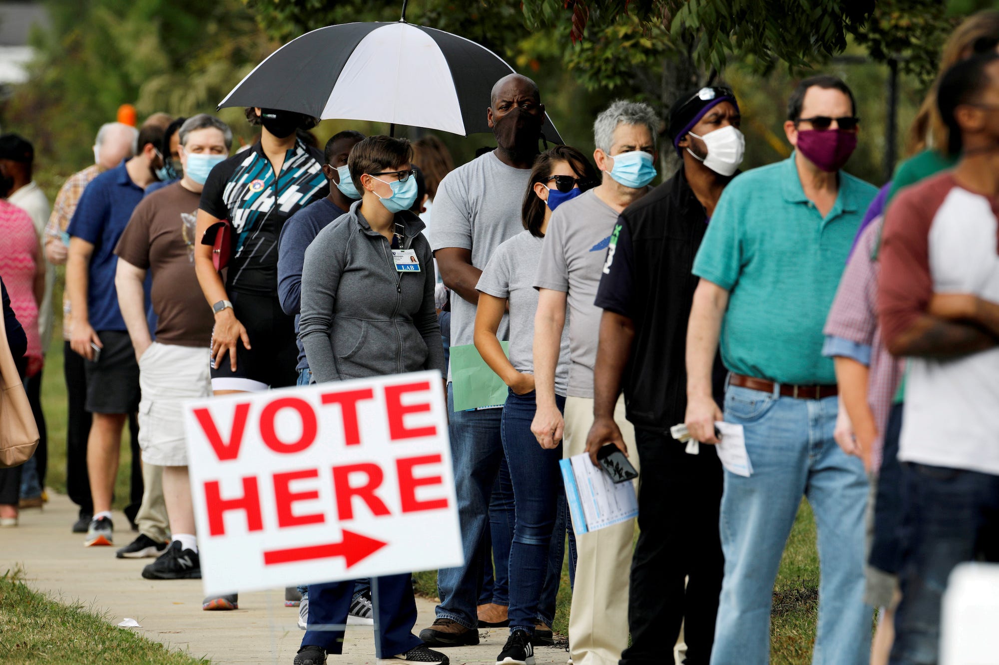 Kiezers wachten in de rij voor een stemlokaal op de eerste dag voor het vervroegd stemmen bij de algemene verkiezingen in Durham, North Carolina, 15 oktober 2020. Reuters/Jonathan Drake