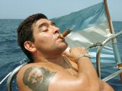 Diego Maradona rookt een sigaar op een boot in het jaar 2000